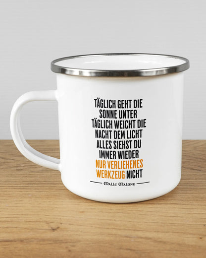 Titelbild, das die linke Seite der beidseitig bedruckten Emailletasse von Maondo mit dem Design Wegzeug in der Farbe White-Silver auf einem Holztisch zeigt