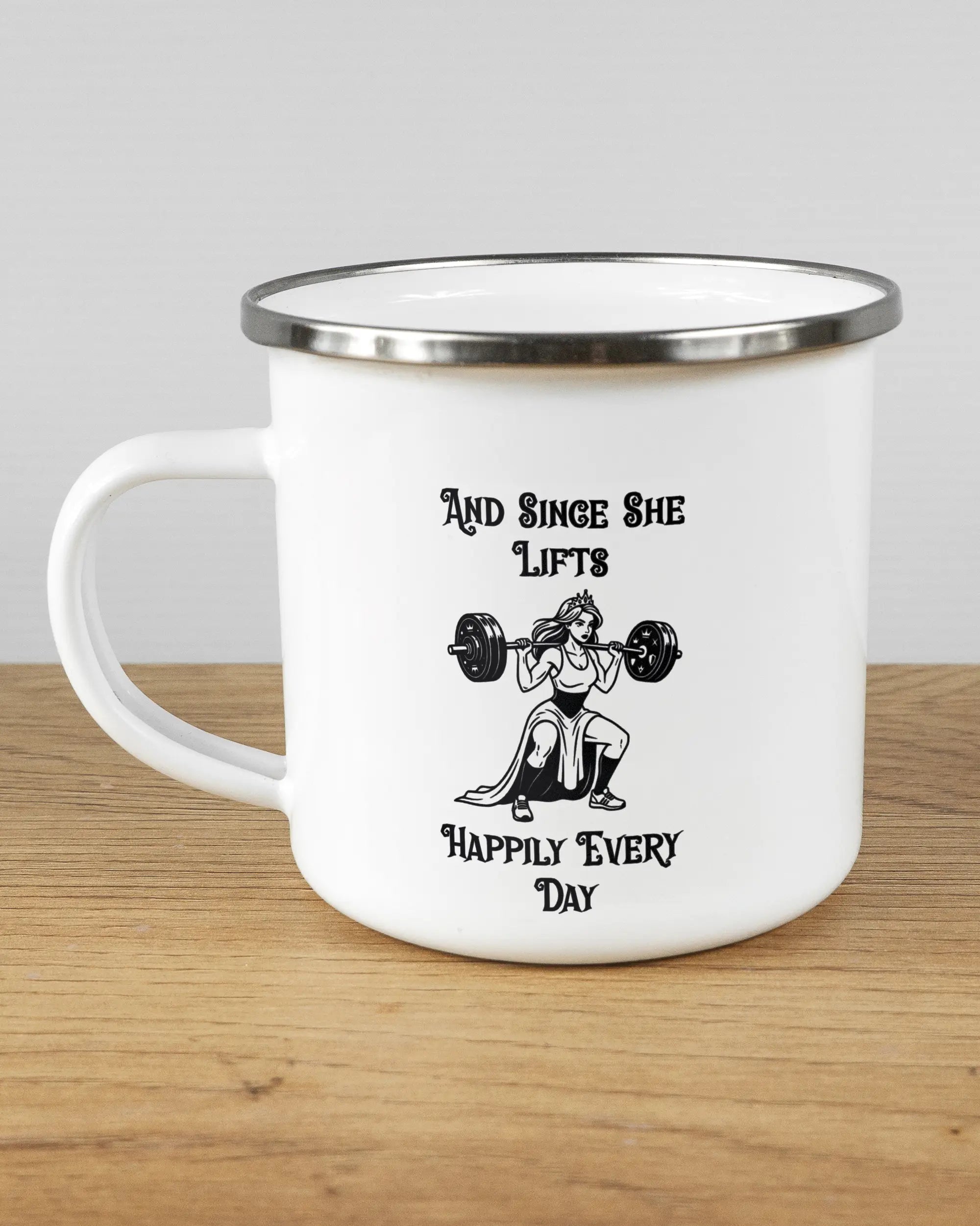 Titelbild, das die linke Seite der beidseitig bedruckten Emailletasse von Maondo mit dem Design Princess Lift in der Farbe White-Silver auf einem Holztisch zeigt