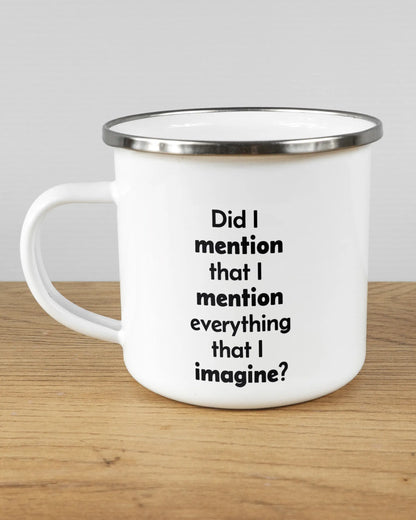 Titelbild, das die linke Seite der beidseitig bedruckten Emailletasse von Maondo mit dem Design Did I mention in der Farbe White-Silver auf einem Holztisch zeigt