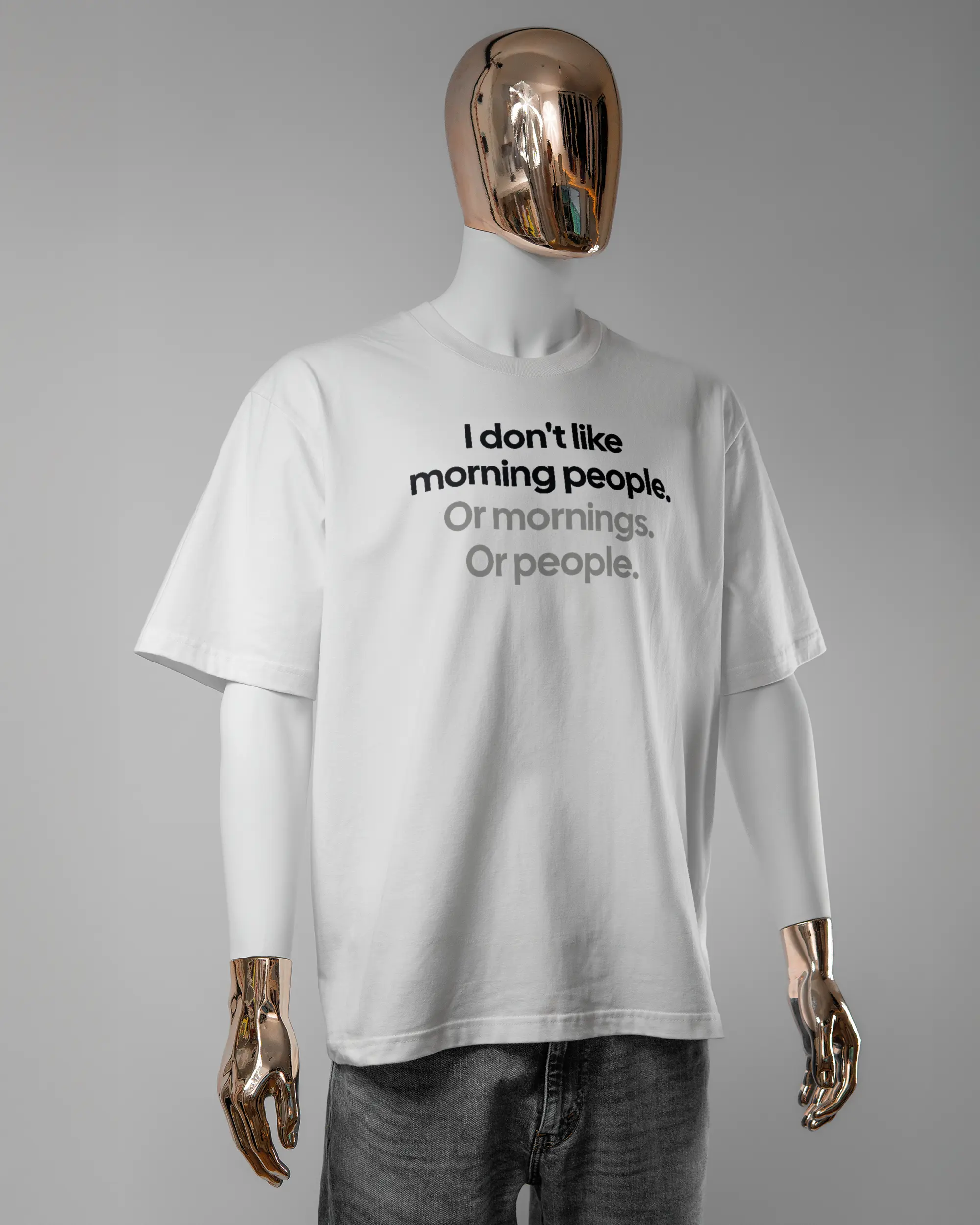 Vorderseite des Basic Unisex T-Shirt Oversized von Maondo mit dem Design Morning Person in der Farbe White und in der Größe L getragen von einer maskulinen Puppe