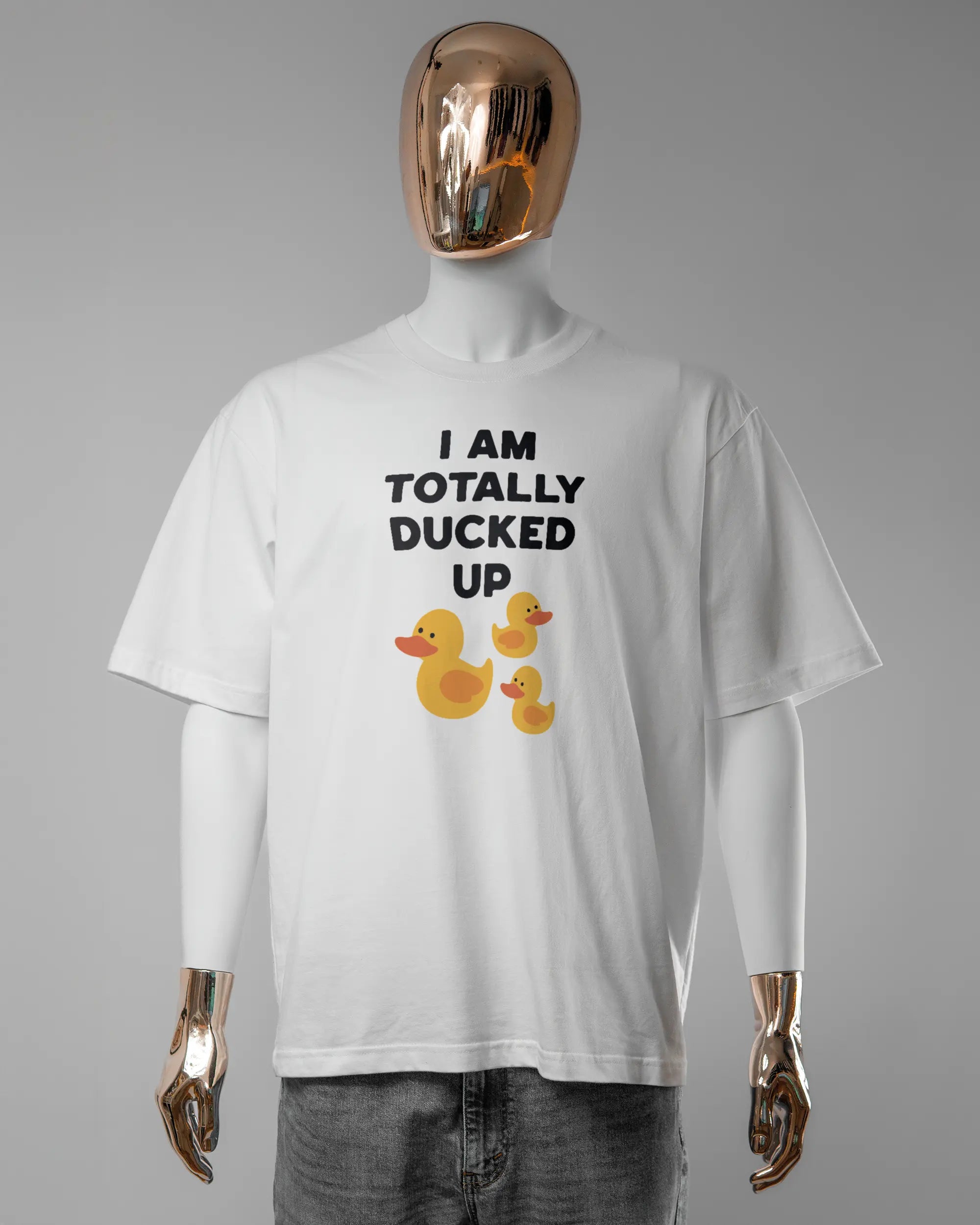 Vorderseite des Basic Unisex T-Shirt Oversized von Maondo mit dem Design Ducked Up in der Farbe White und in der Größe L getragen von einer maskulinen Puppe