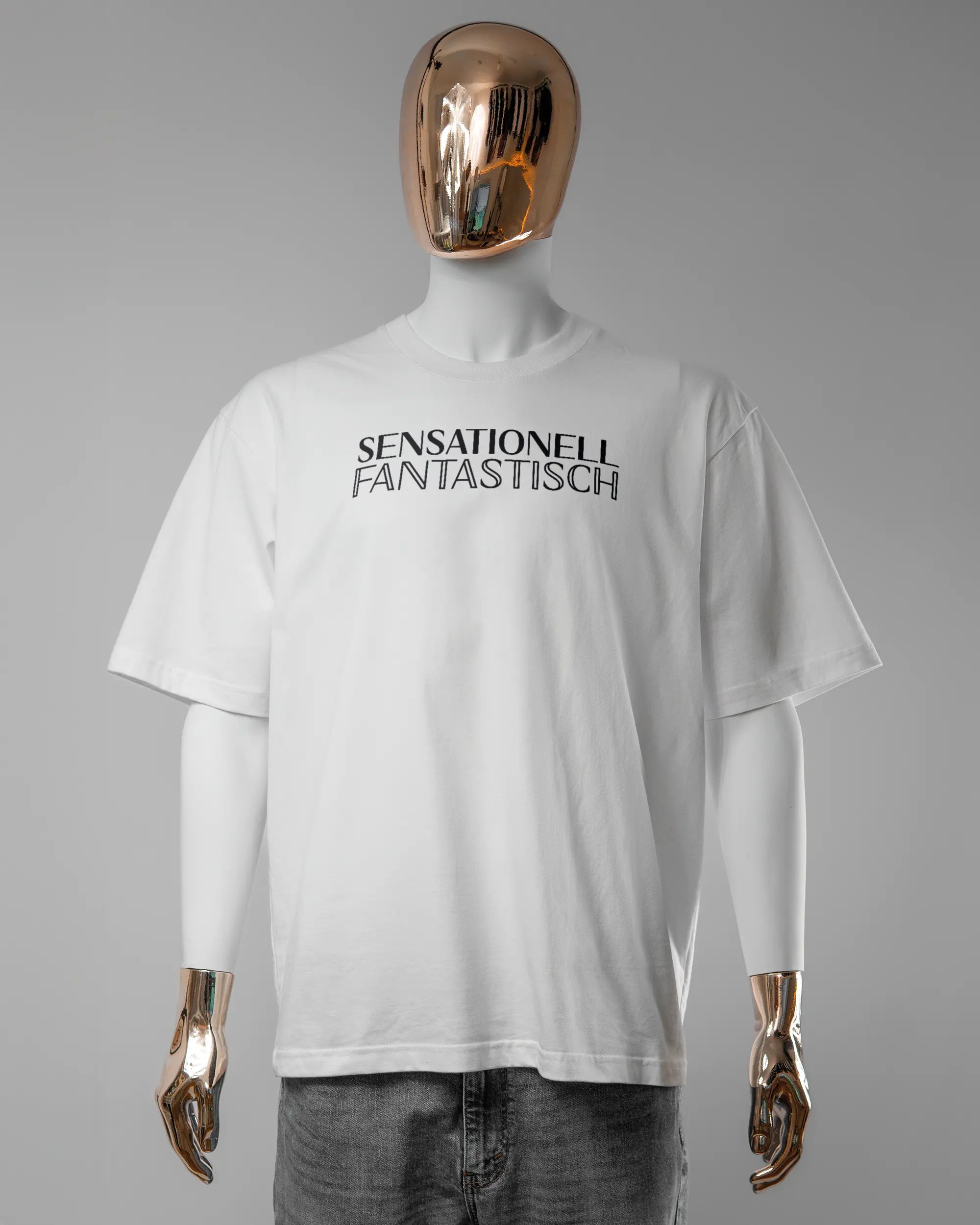 Vorderseite des Basic Unisex T-Shirt Oversized von Maondo mit dem Design Sensationell in der Farbe White und in der Größe L getragen von einer maskulinen Puppe