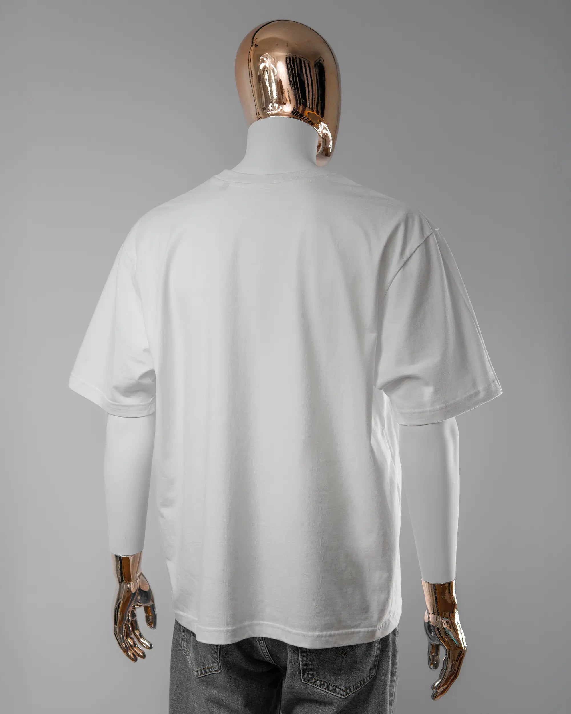 Rückseite des Basic Unisex T-Shirt Oversized von Maondo ohne Motiv in der Farbe White und in der Größe L getragen von einer maskulinen Puppe