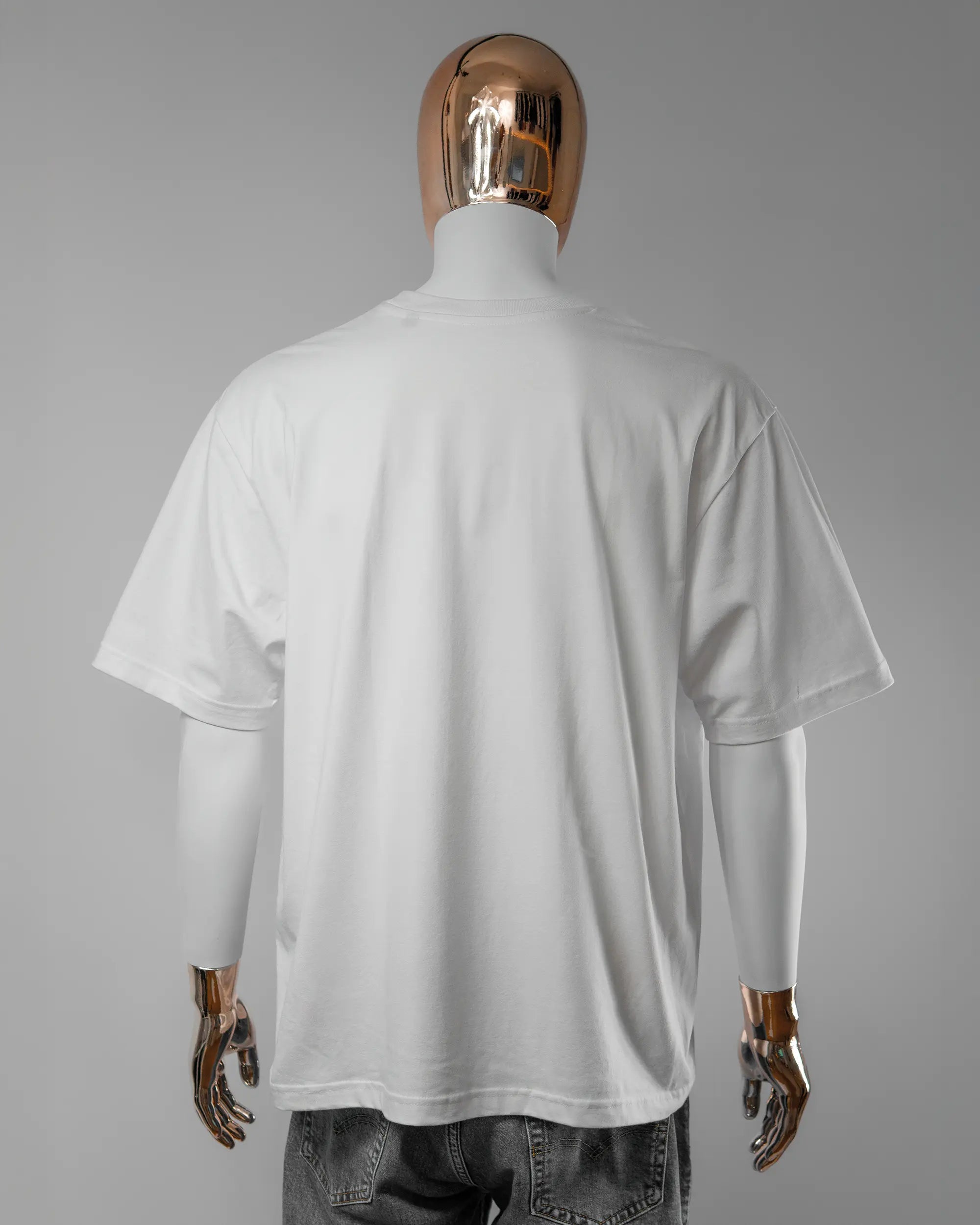 Rückseite des Basic Unisex T-Shirt Oversized von Maondo ohne Motiv in der Farbe White und in der Größe L getragen von einer maskulinen Puppe