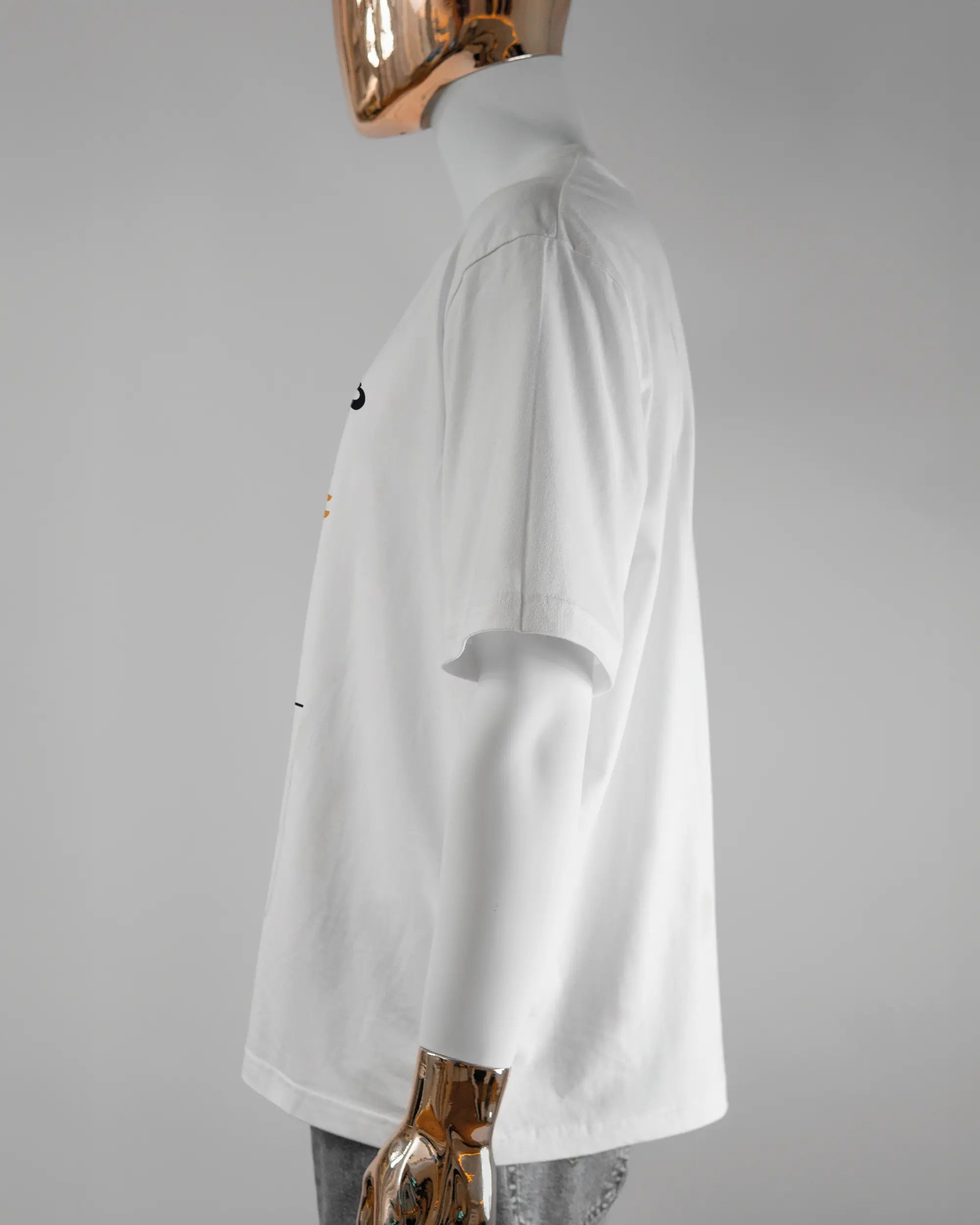 Seitenansicht des Basic Unisex T-Shirt Oversized von Maondo mit dem Design We are one vorne in der Farbe White und in der Größe L getragen von einer maskulinen Puppe
