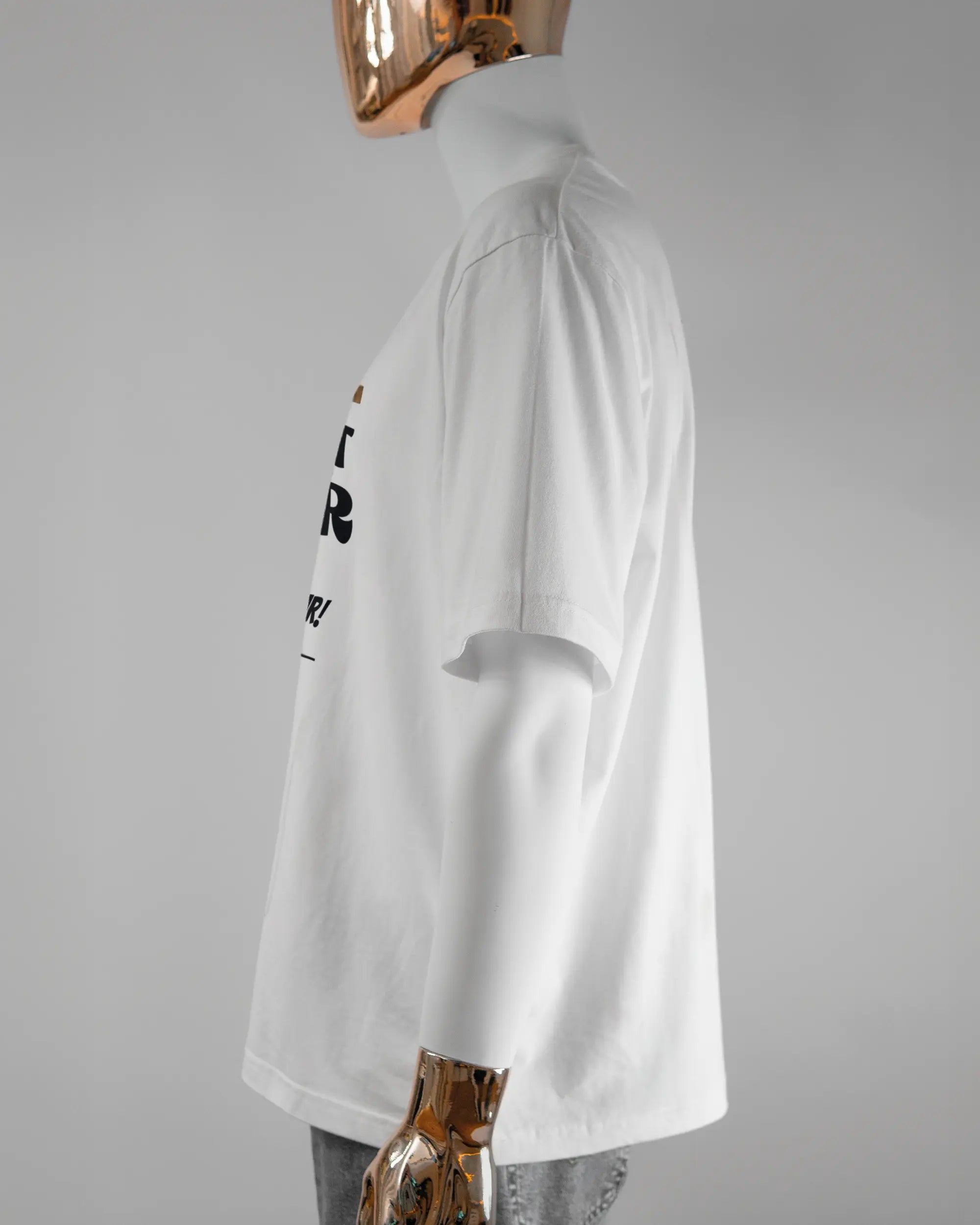 Seitenansicht des Basic Unisex T-Shirt Oversized von Maondo mit dem Design Holzarbeit vorne in der Farbe White und in der Größe L getragen von einer maskulinen Puppe