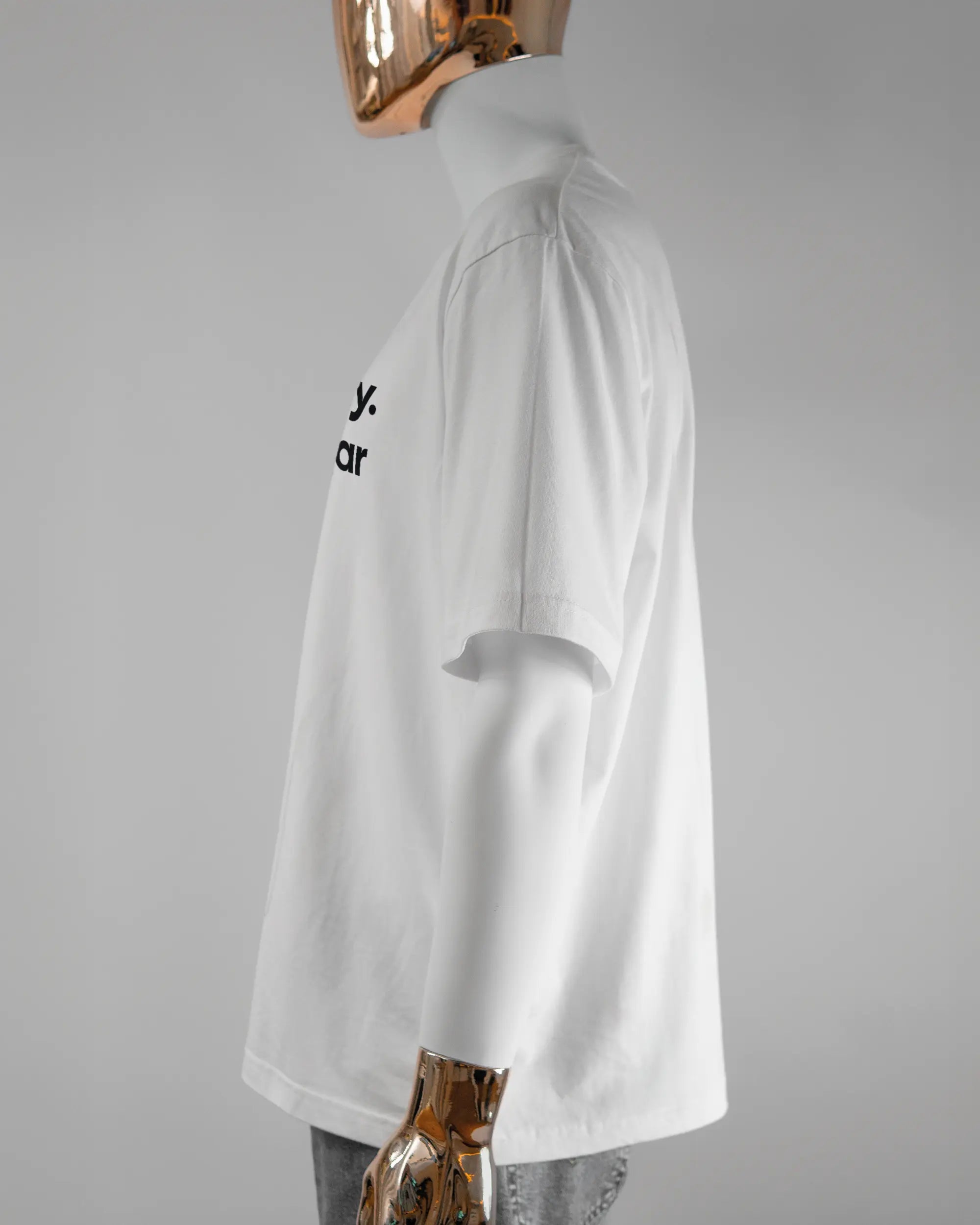 Seitenansicht des Basic Unisex T-Shirt Oversized von Maondo mit dem Design Colorful Day vorne in der Farbe White und in der Größe L getragen von einer maskulinen Puppe