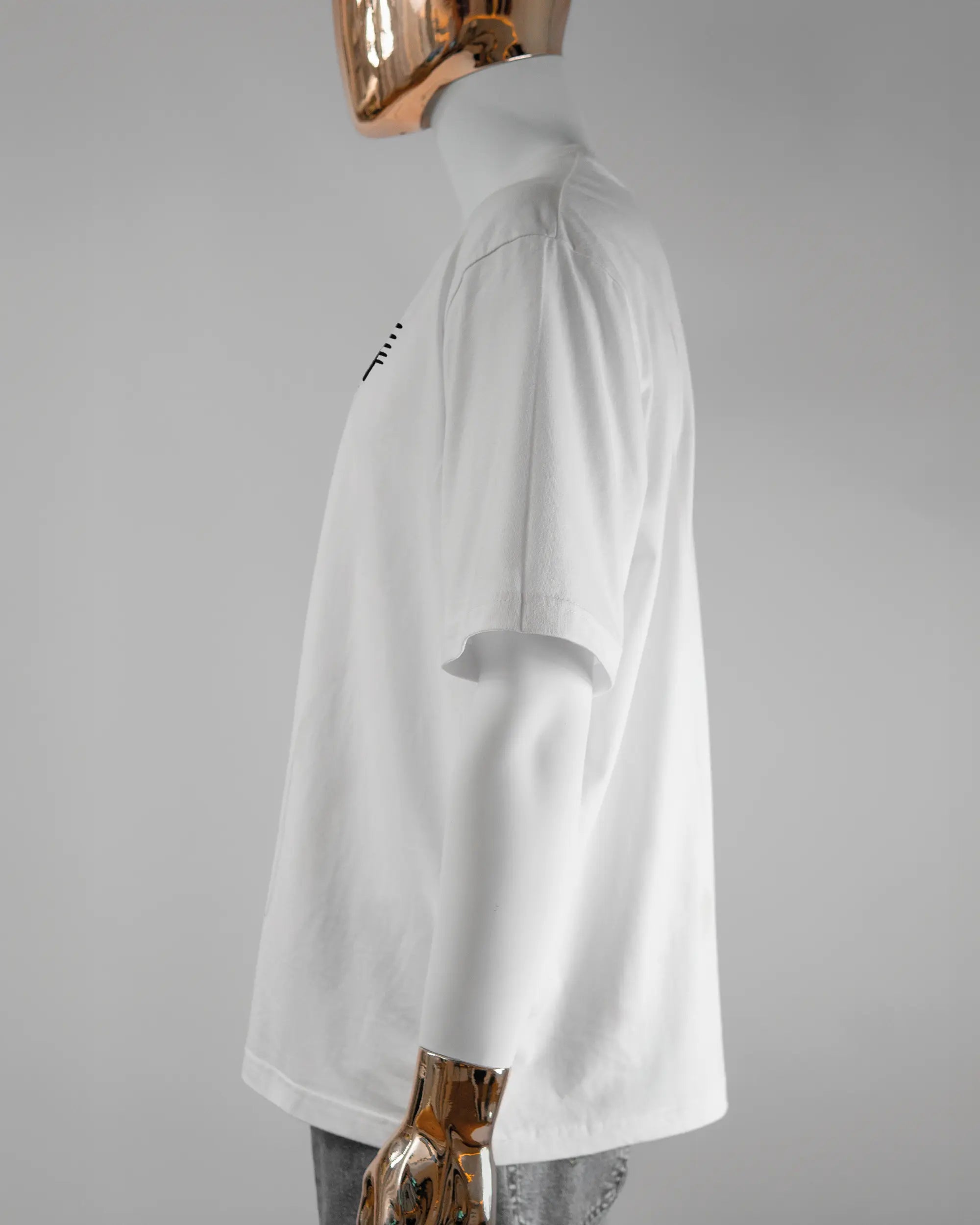 Seitenansicht des Basic Unisex T-Shirt Oversized von Maondo mit dem Design Hidden Message vorne in der Farbe White und in der Größe L getragen von einer maskulinen Puppe