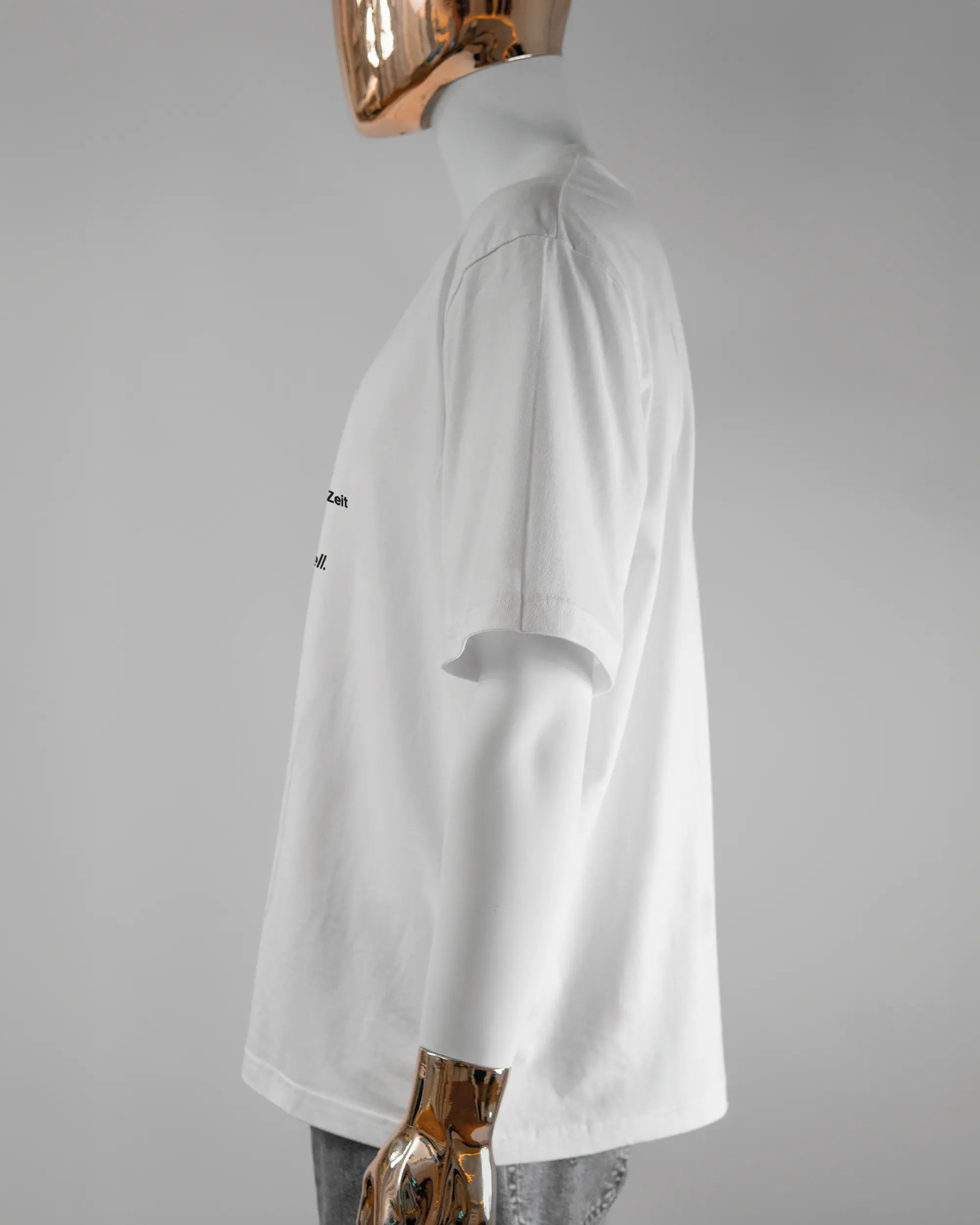 Seitenansicht des Basic Unisex T-Shirt Oversized von Maondo mit dem Design Schniell vorne in der Farbe White und in der Größe L getragen von einer maskulinen Puppe