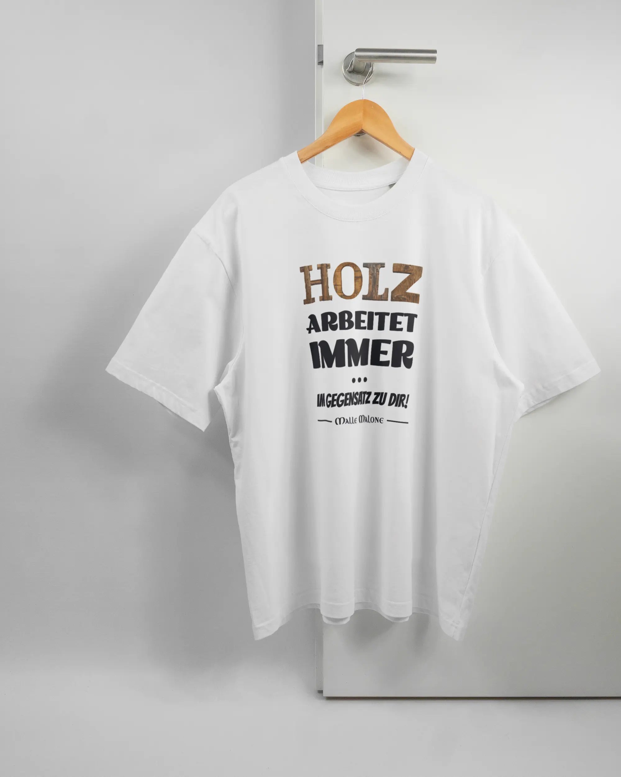 Vorderseite des Basic Unisex T-Shirt Oversized von Maondo mit dem Design Holzarbeit in der Farbe White und in der Größe L auf einem Bügel an der Türklinke aufgehängt