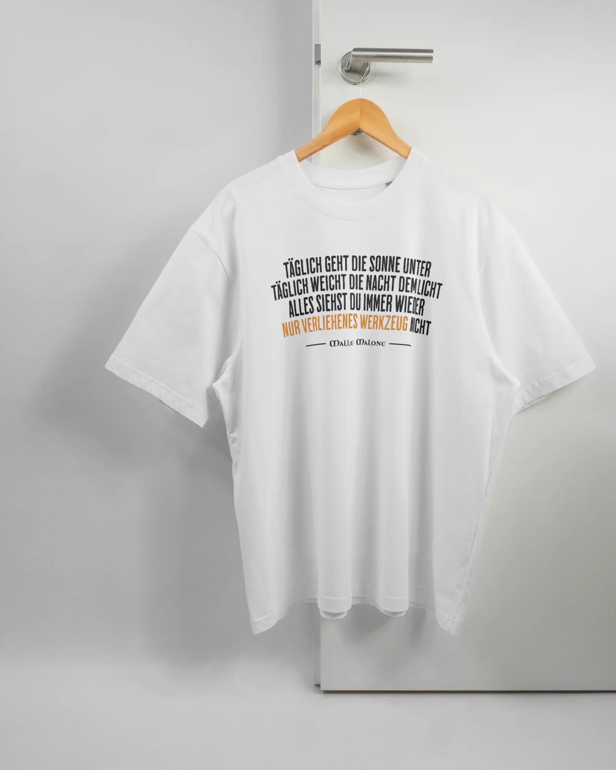 Vorderseite des Basic Unisex T-Shirt Oversized von Maondo mit dem Design Wegzeug in der Farbe White und in der Größe L auf einem Bügel an der Türklinke aufgehängt