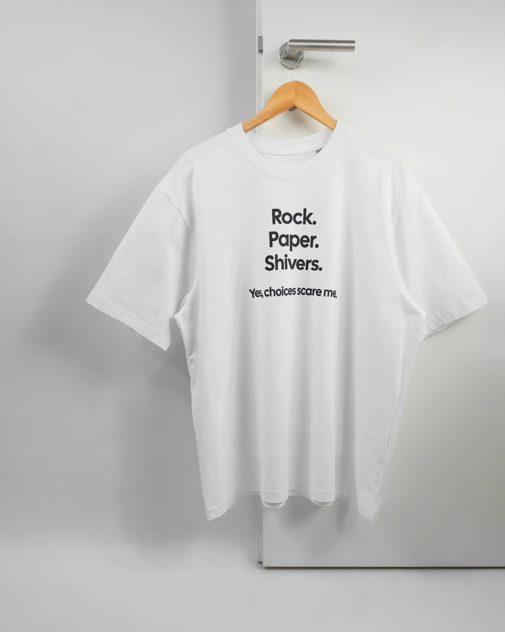 Vorderseite des Basic Unisex T-Shirt Oversized von Maondo mit dem Design Rock Paper Shivers in der Farbe White und in der Größe L auf einem Bügel an der Türklinke aufgehängt