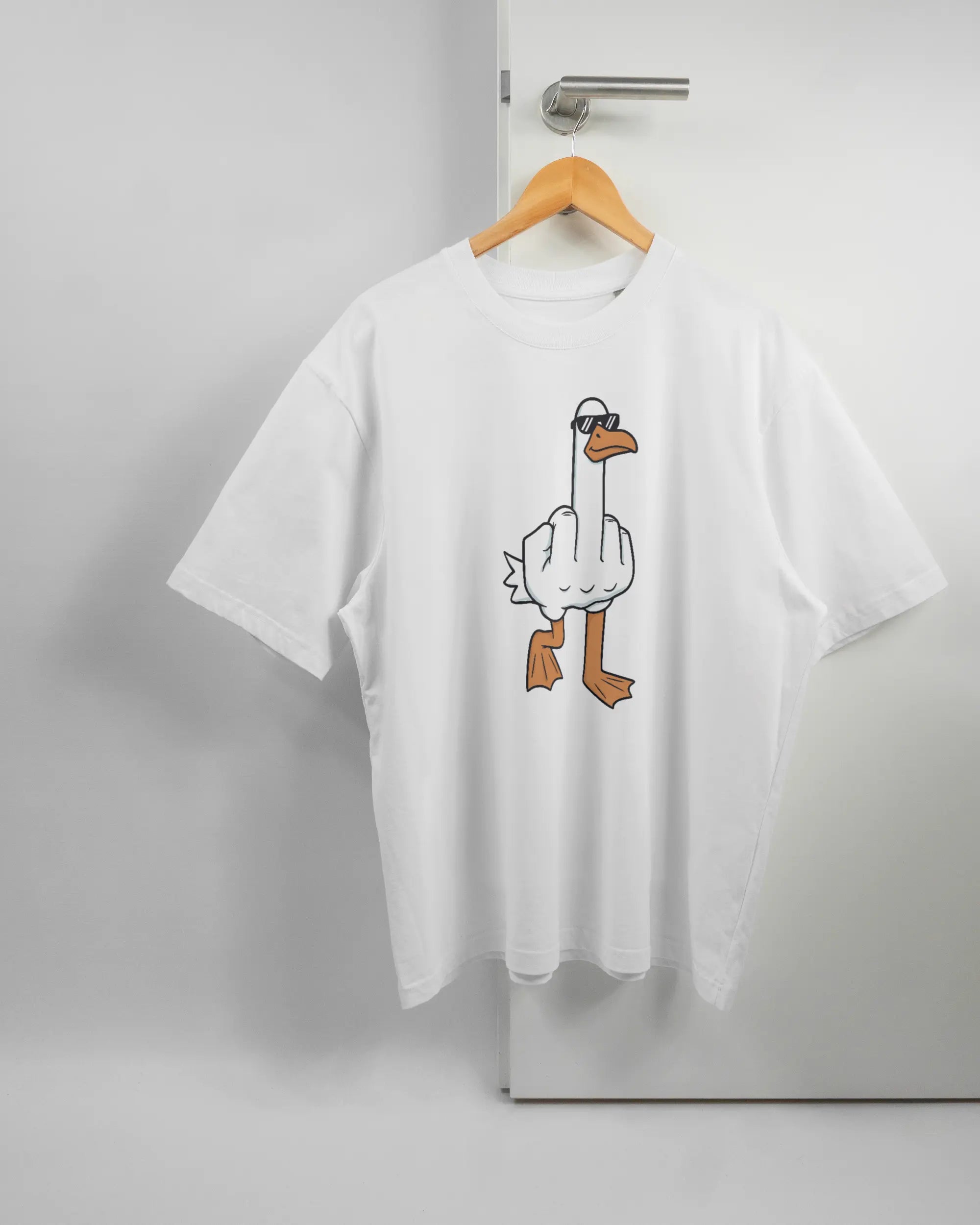 Vorderseite des Basic Unisex T-Shirt Oversized von Maondo mit dem Design I give a duck in der Farbe White und in der Größe L auf einem Bügel an der Türklinke aufgehängt