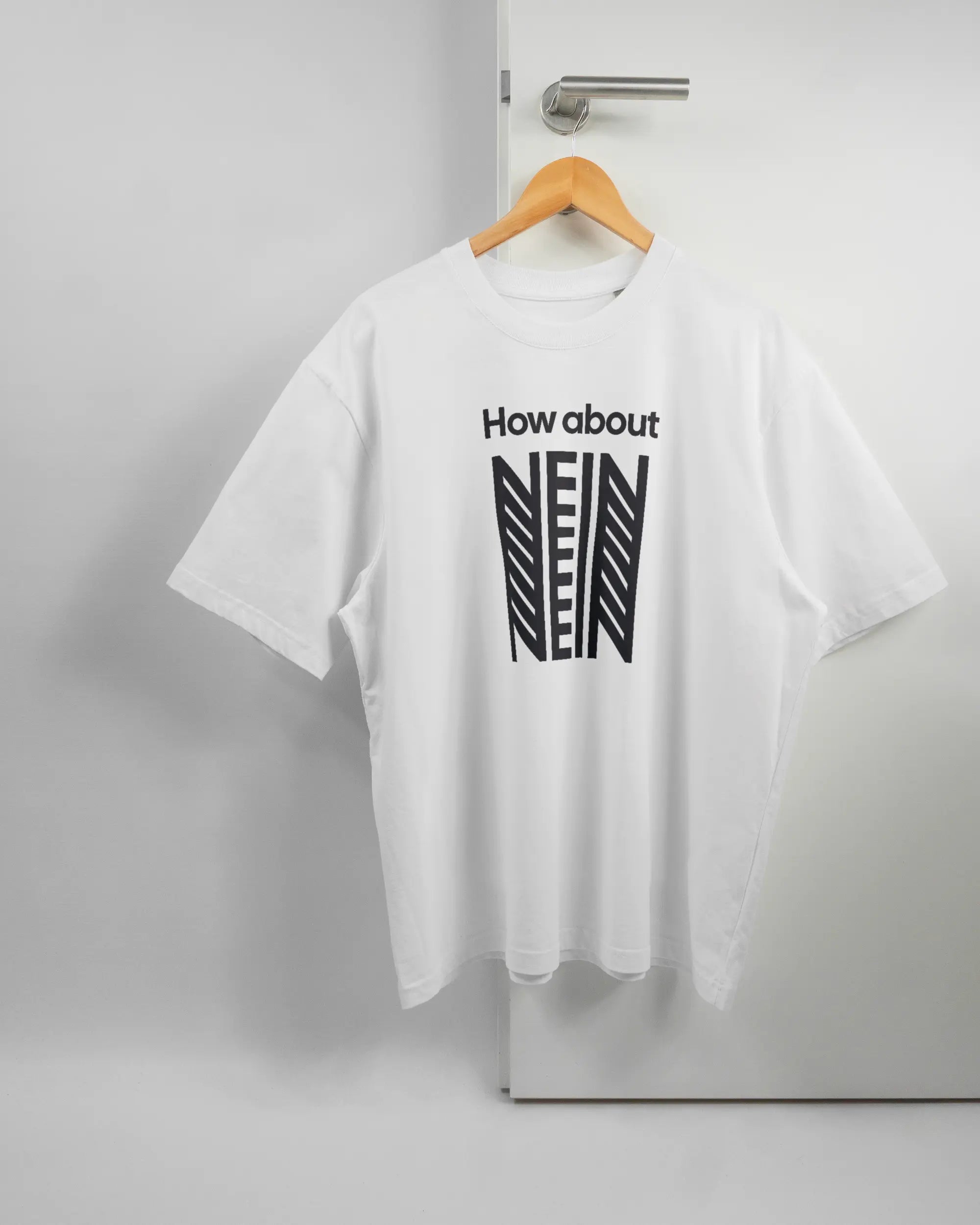 Vorderseite des Basic Unisex T-Shirt Oversized von Maondo mit dem Design How about nein in der Farbe White und in der Größe L auf einem Bügel an der Türklinke aufgehängt