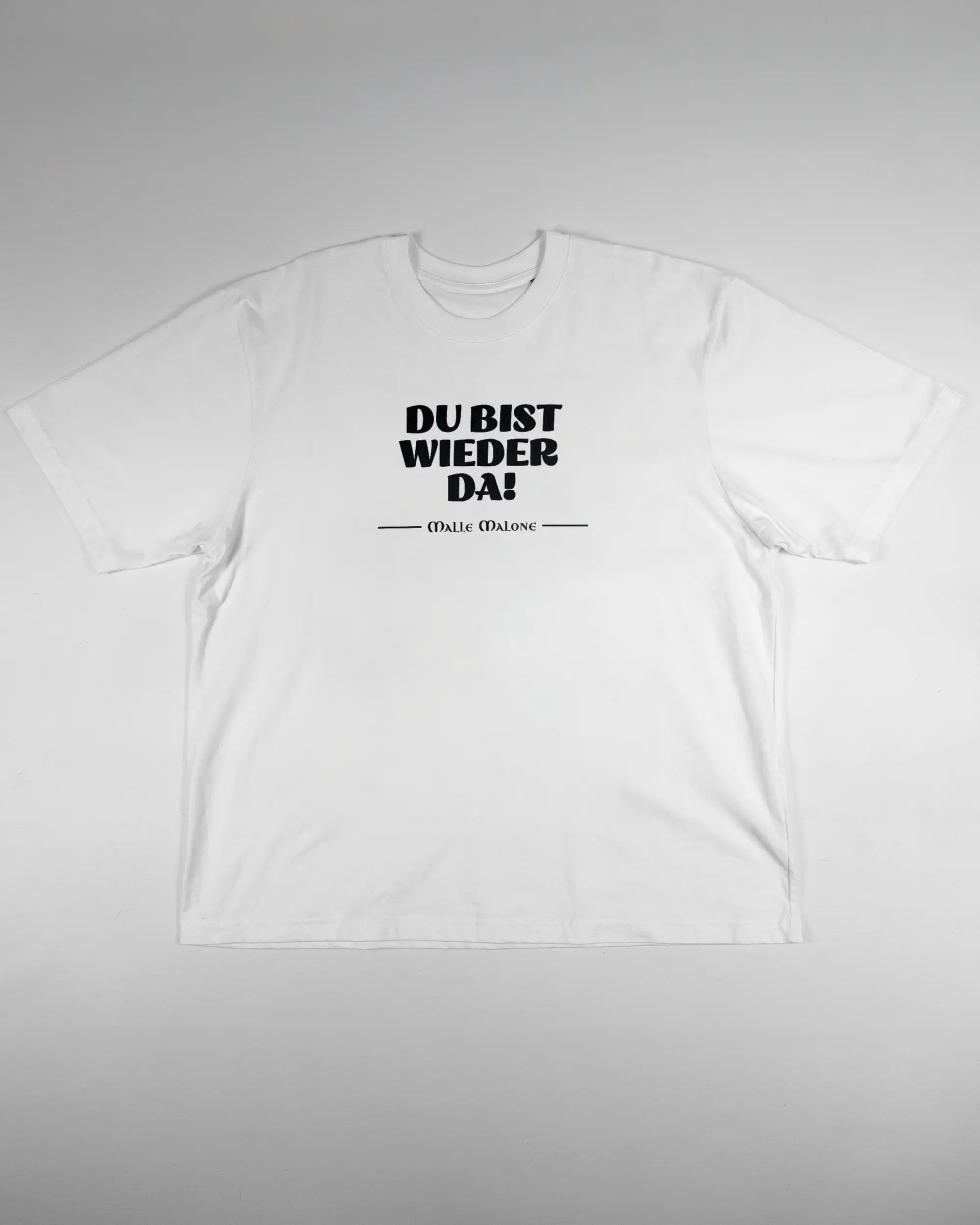 Vorderseite des Basic Unisex T-Shirt Oversized von Maondo mit dem Design Wieder da in der Farbe White und in der Größe L flach auf den Boden gelegt