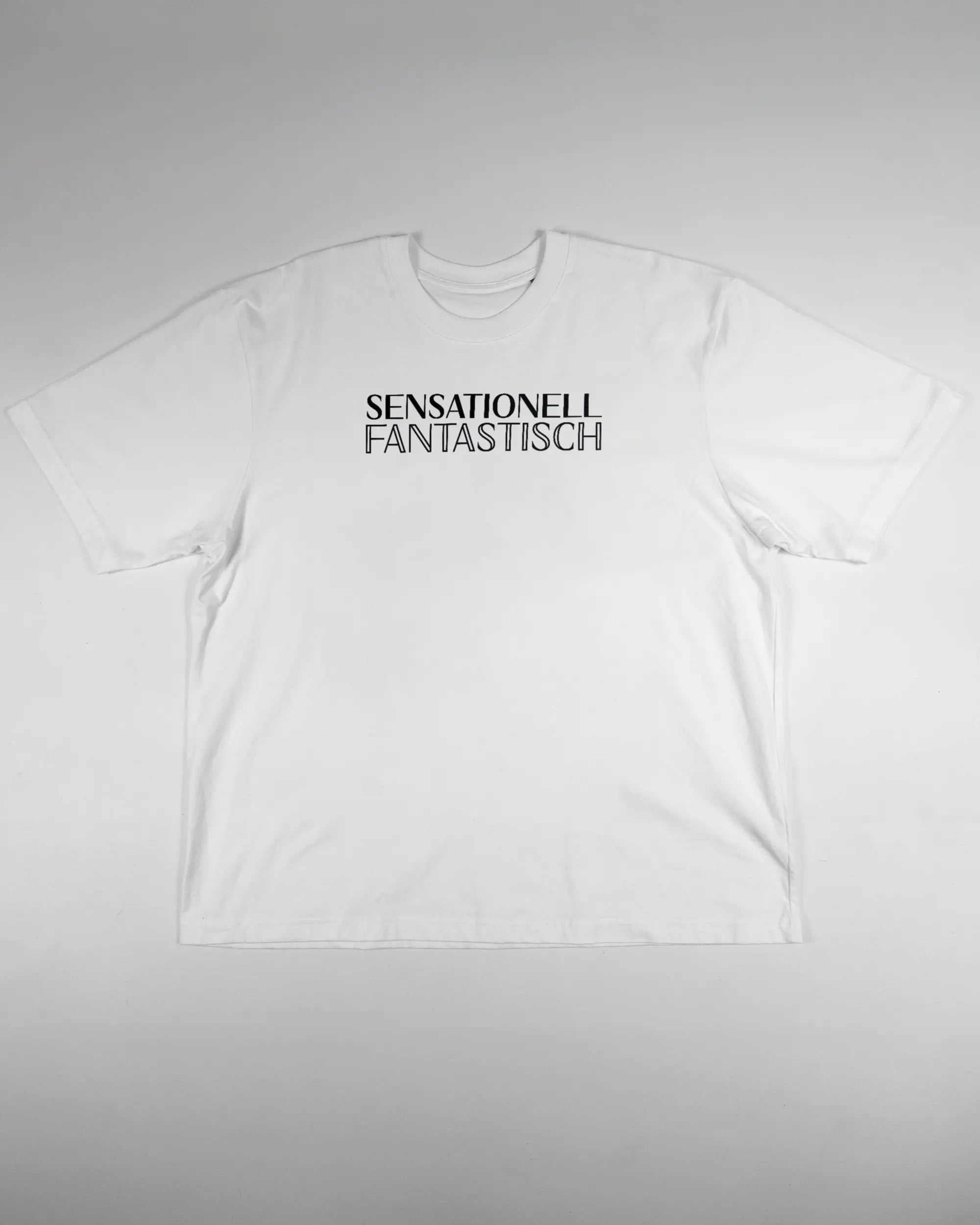 Vorderseite des Basic Unisex T-Shirt Oversized von Maondo mit dem Design Sensationell in der Farbe White und in der Größe L flach auf den Boden gelegt