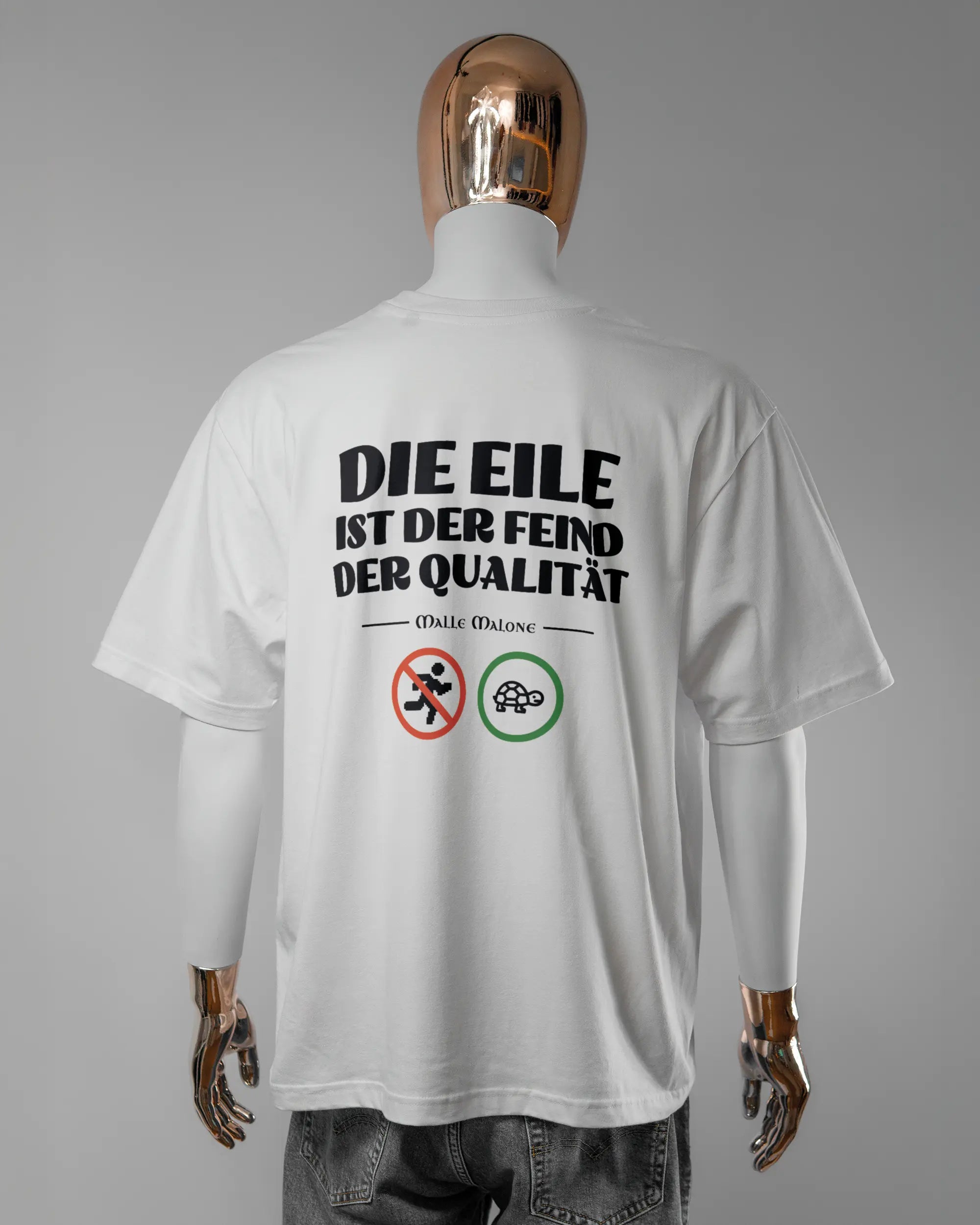 Rückseite des Basic Unisex T-Shirt Oversized von Maondo mit dem Design Keine Eile in der Farbe White und in der Größe L getragen von einer maskulinen Puppe