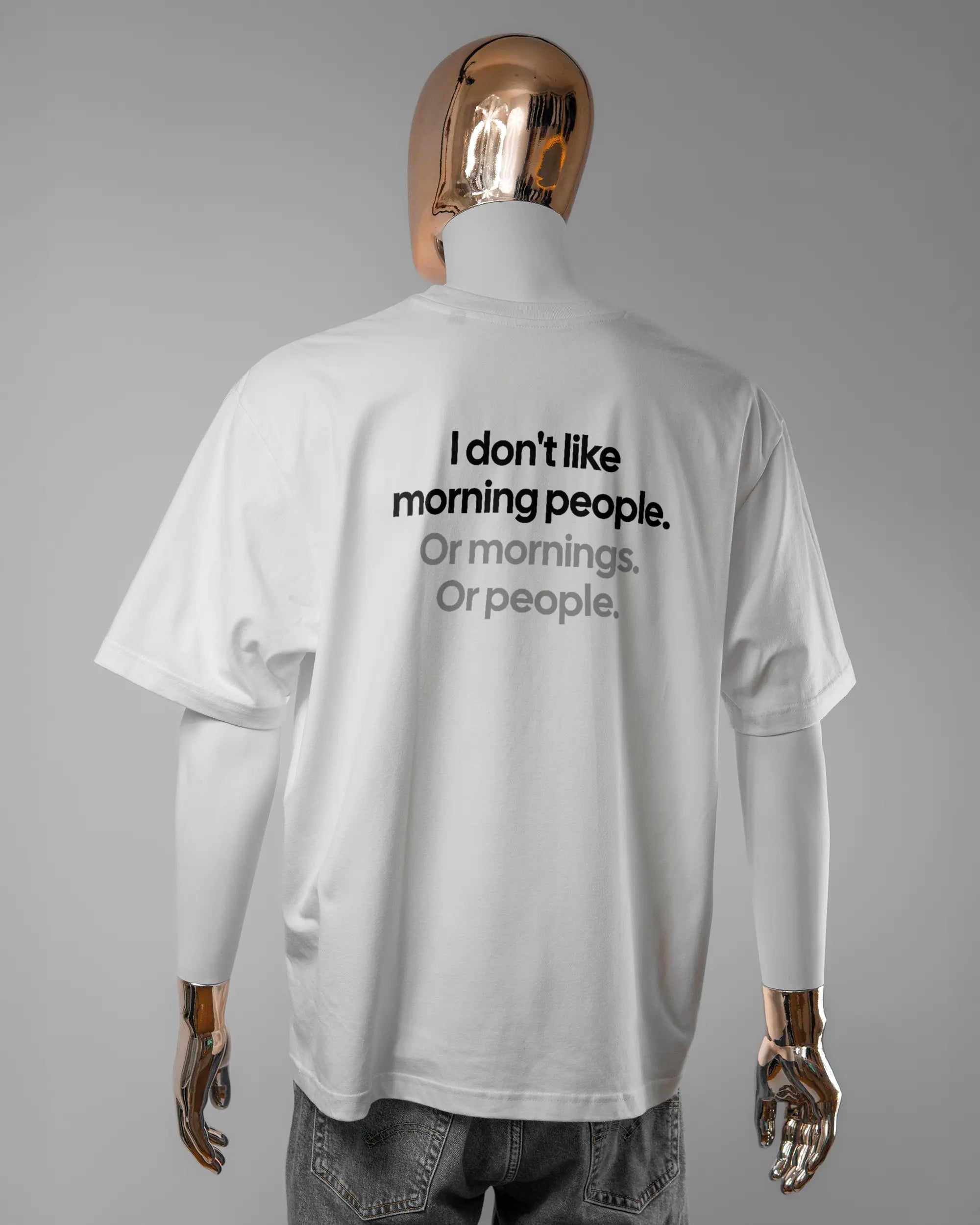 Rückseite des Basic Unisex T-Shirt Oversized von Maondo mit dem Design Morning Person in der Farbe White und in der Größe L getragen von einer maskulinen Puppe