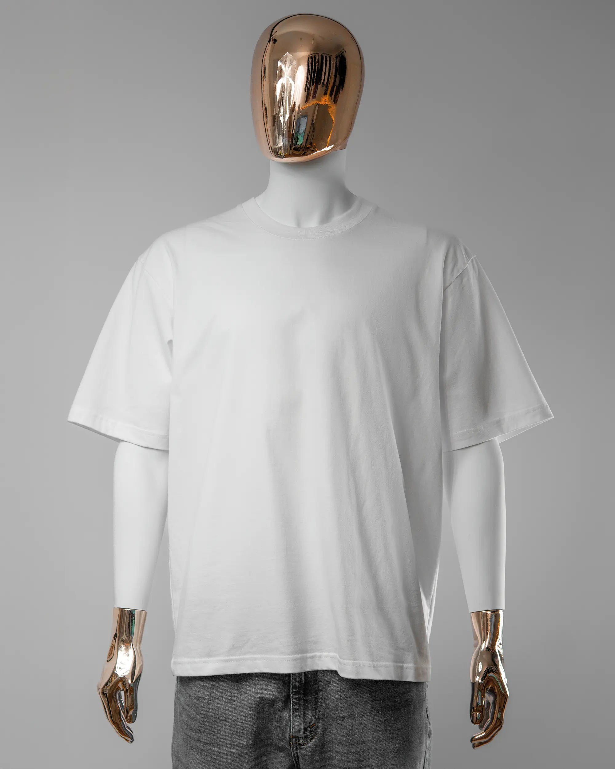 Vorderseite des Basic Unisex T-Shirt Oversized von Maondo ohne Motiv in der Farbe White und in der Größe L getragen von einer maskulinen Puppe