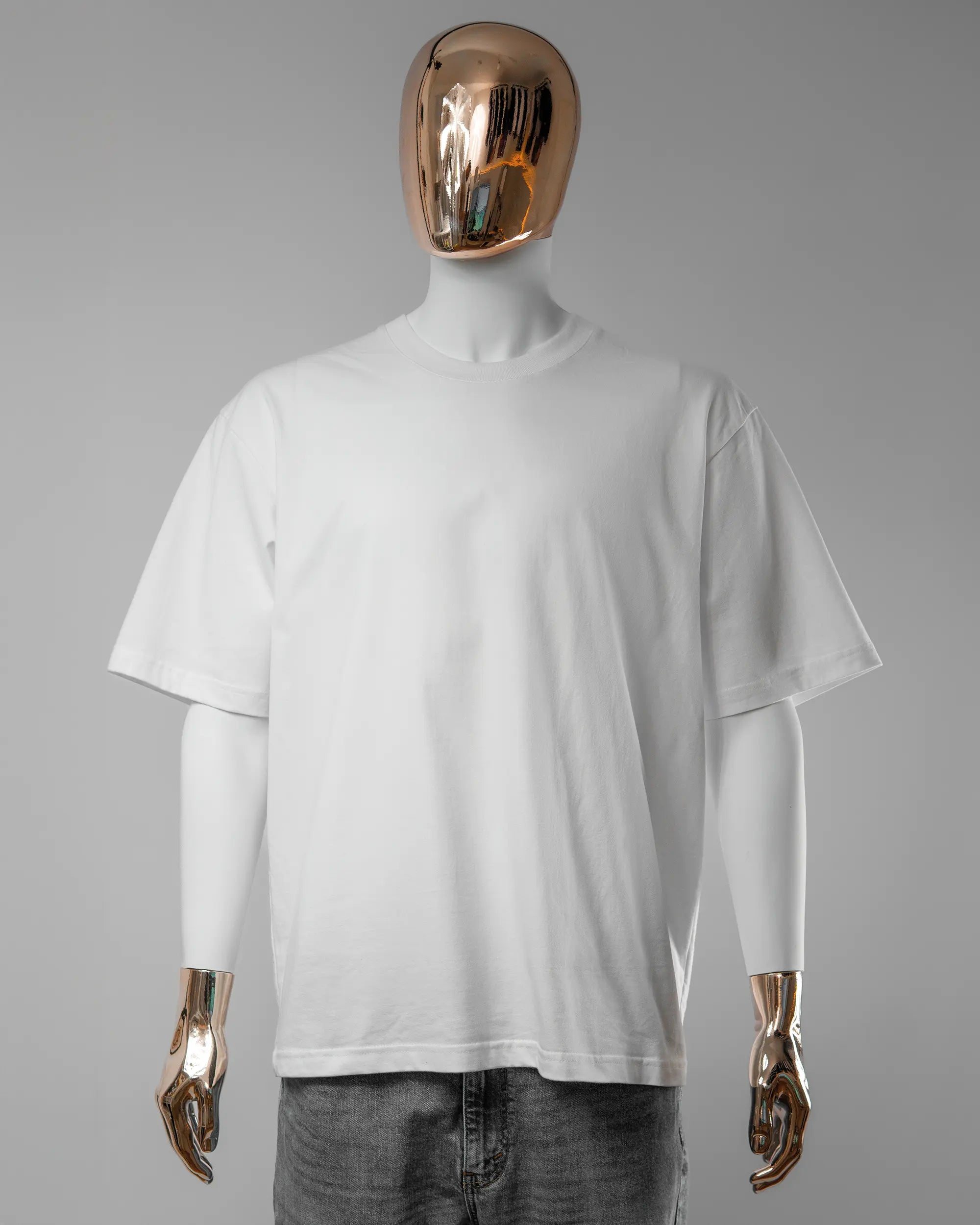 Vorderseite des Basic Unisex T-Shirt Oversized von Maondo ohne Motiv in der Farbe White und in der Größe L getragen von einer maskulinen Puppe