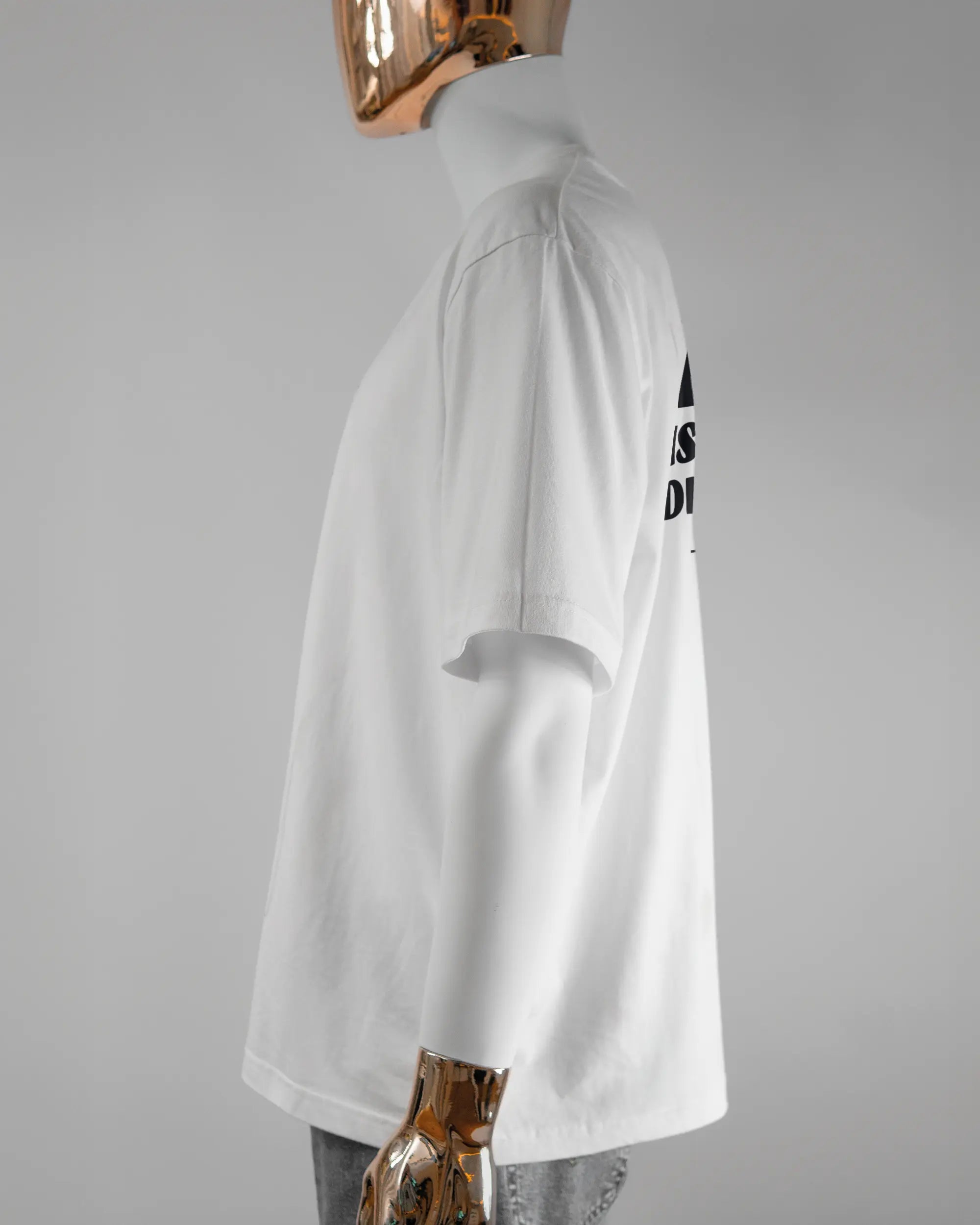 Seitenansicht des Basic Unisex T-Shirt Oversized von Maondo mit dem Design Keine Eile hinten in der Farbe White und in der Größe L getragen von einer maskulinen Puppe