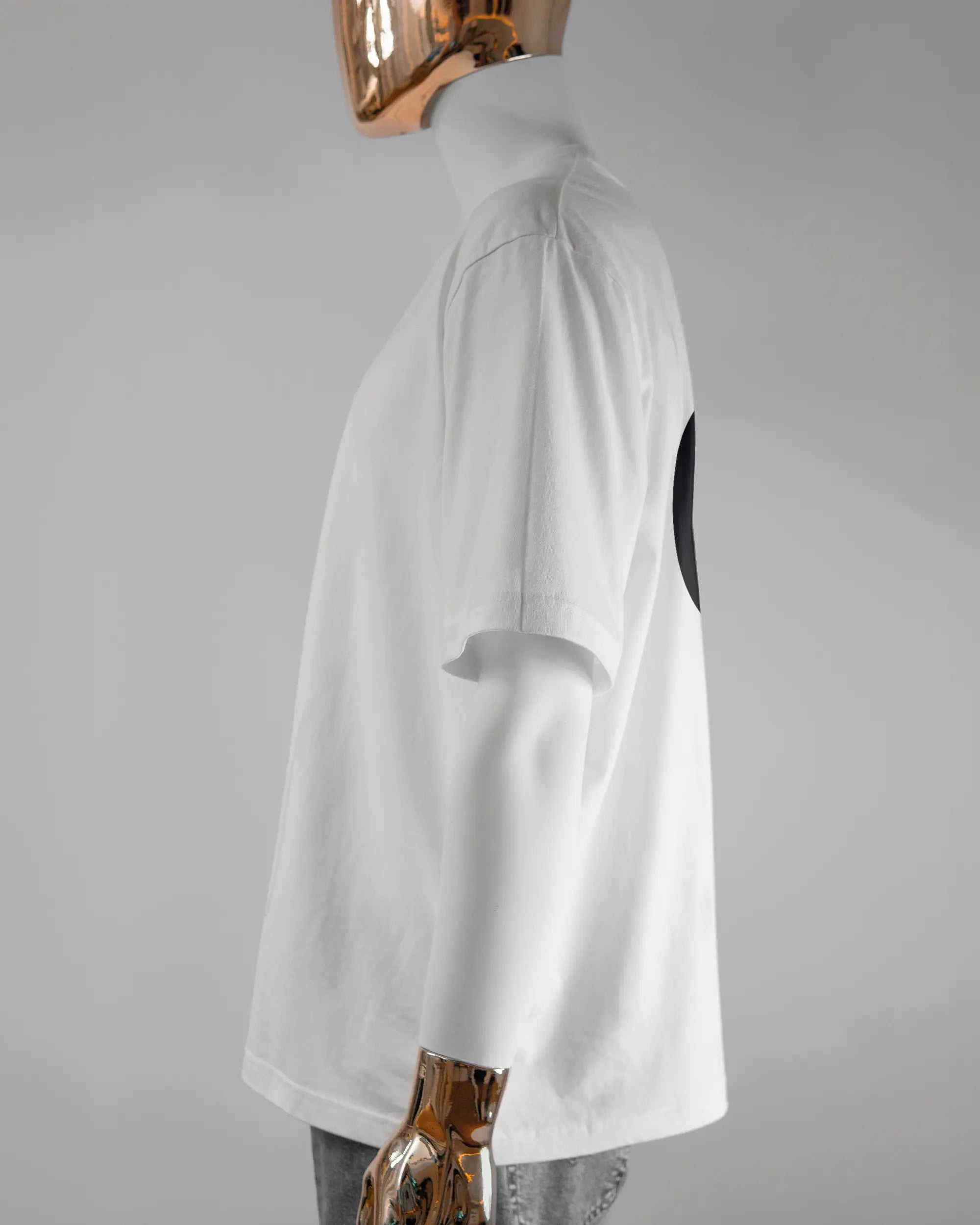 Seitenansicht des Basic Unisex T-Shirt Oversized von Maondo mit dem Design JB1 hinten in der Farbe White und in der Größe L getragen von einer maskulinen Puppe