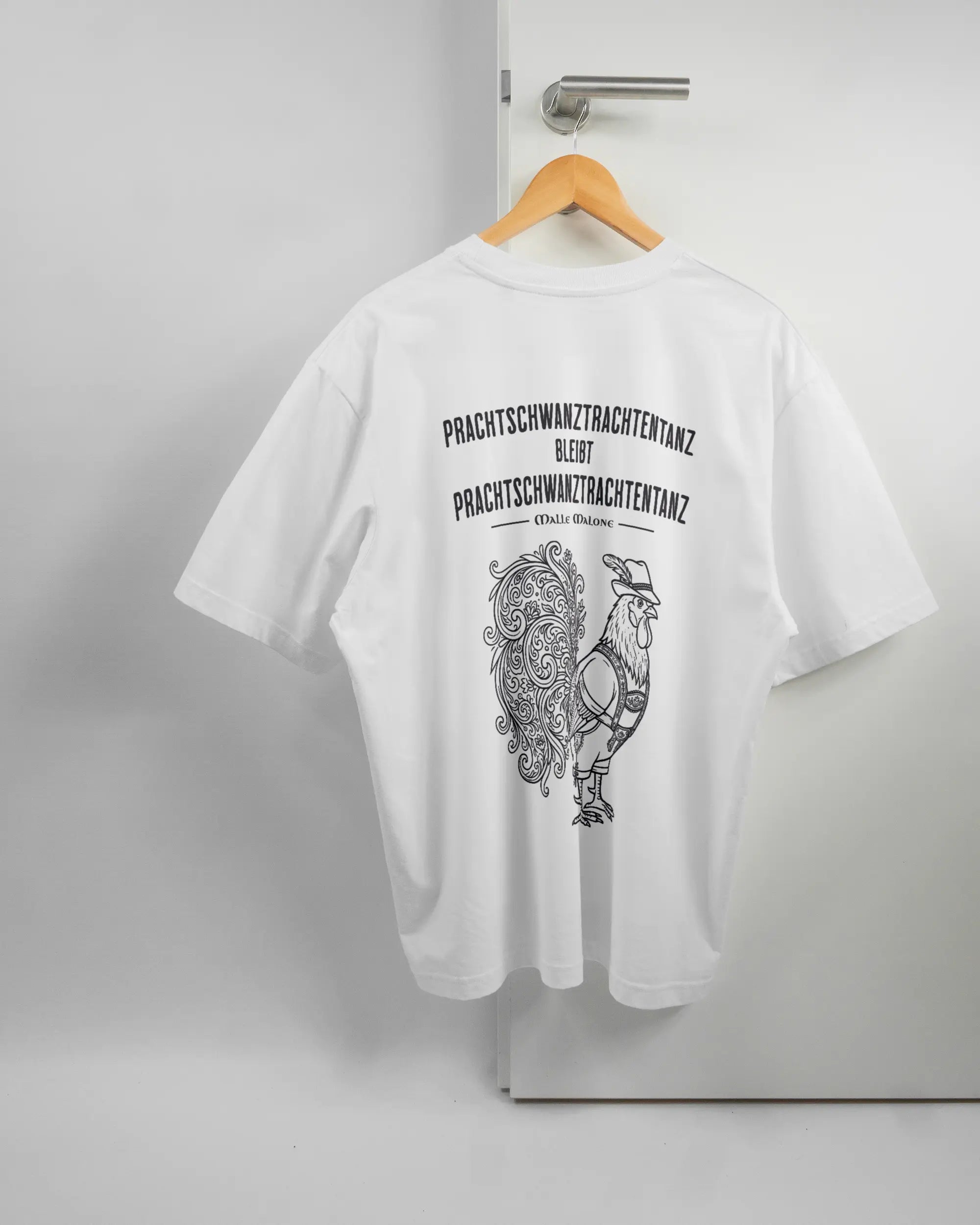 Rückseite des Basic Unisex T-Shirt Oversized von Maondo mit dem Design Trachtentanz in der Farbe White und in der Größe L auf einem Bügel an der Türklinke aufgehängt