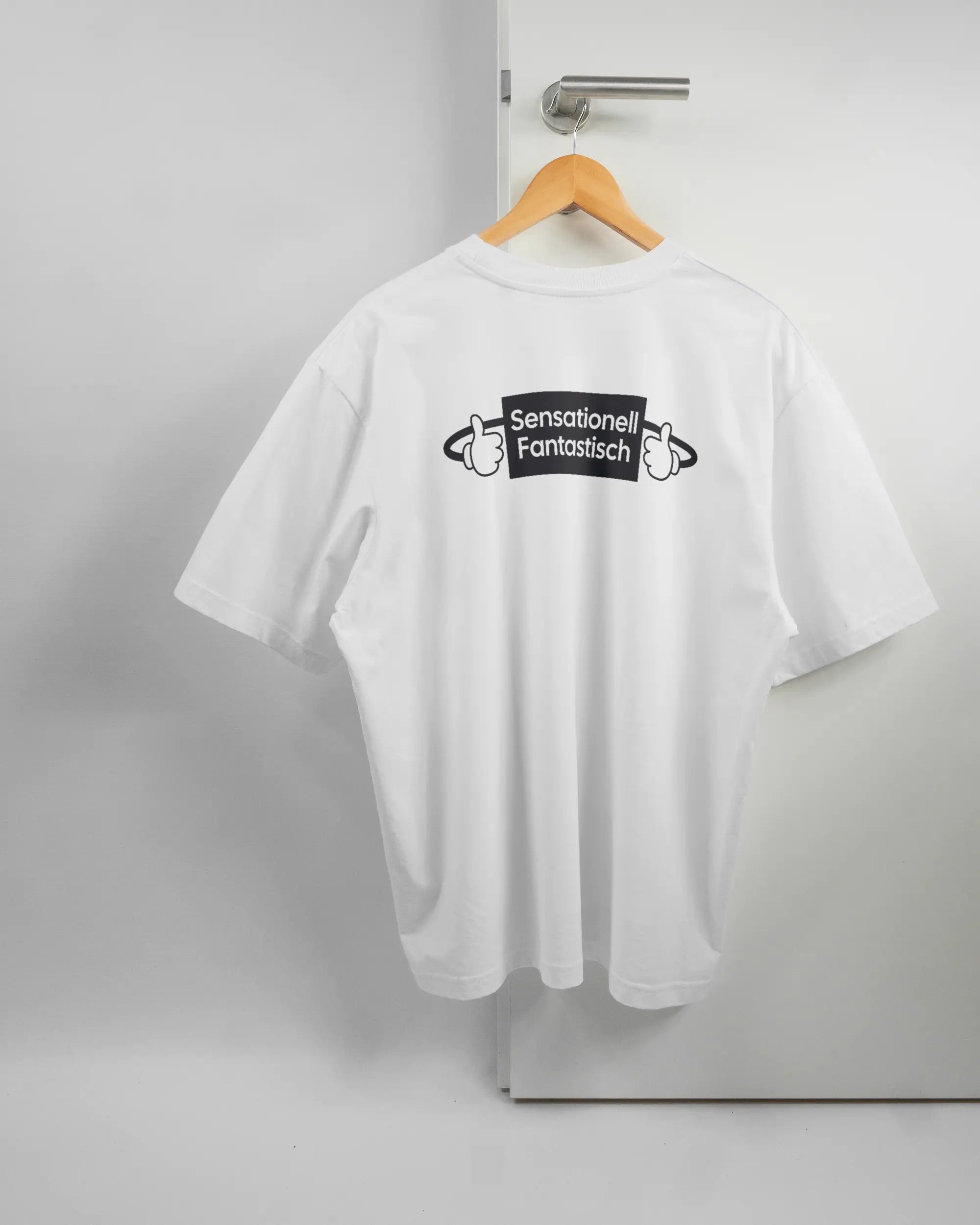 Rückseite des Basic Unisex T-Shirt Oversized von Maondo mit dem Design Fantastisch in der Farbe White und in der Größe L auf einem Bügel an der Türklinke aufgehängt