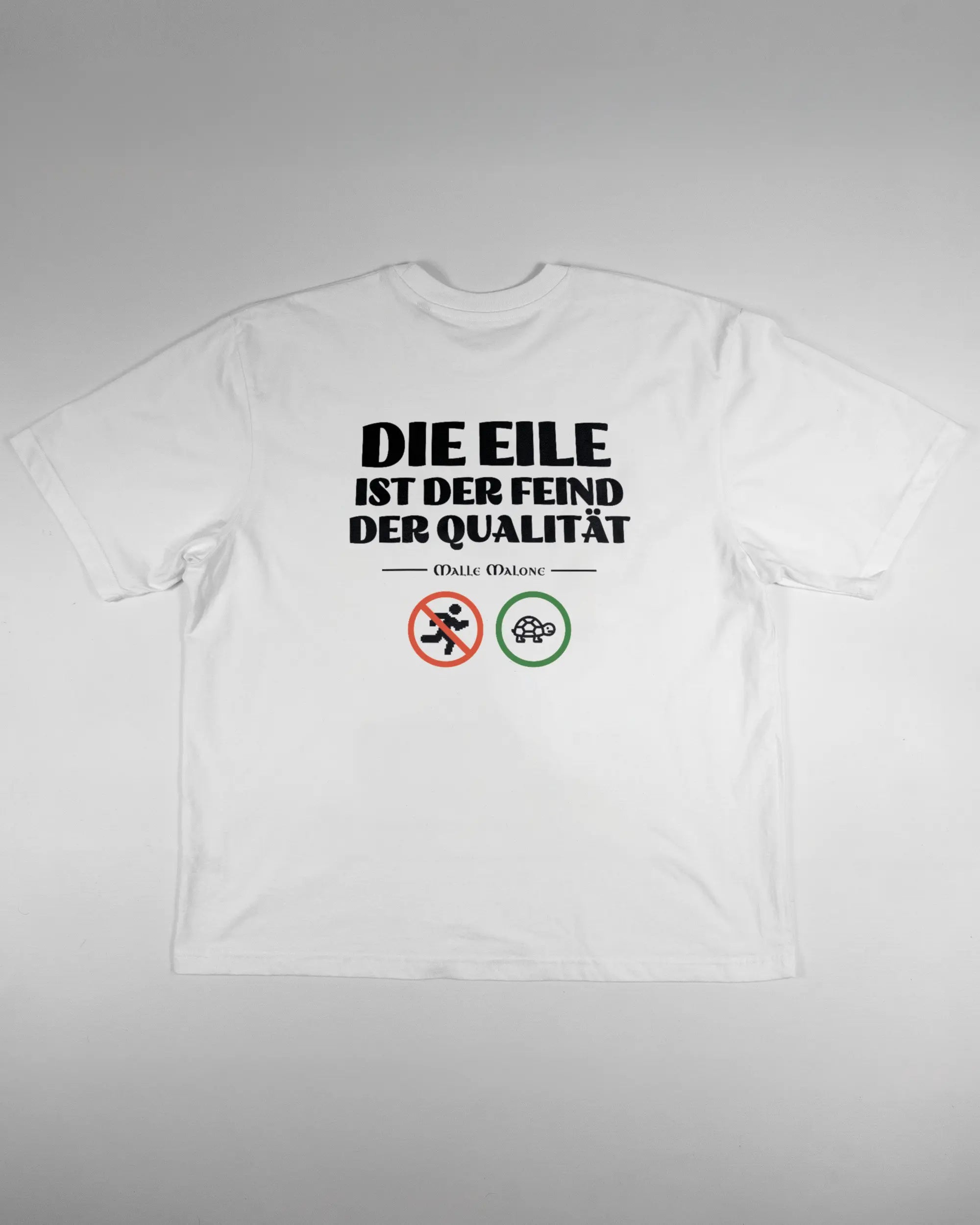 Rückseite des Basic Unisex T-Shirt Oversized von Maondo mit dem Design Keine Eile in der Farbe White und in der Größe L flach auf den Boden gelegt
