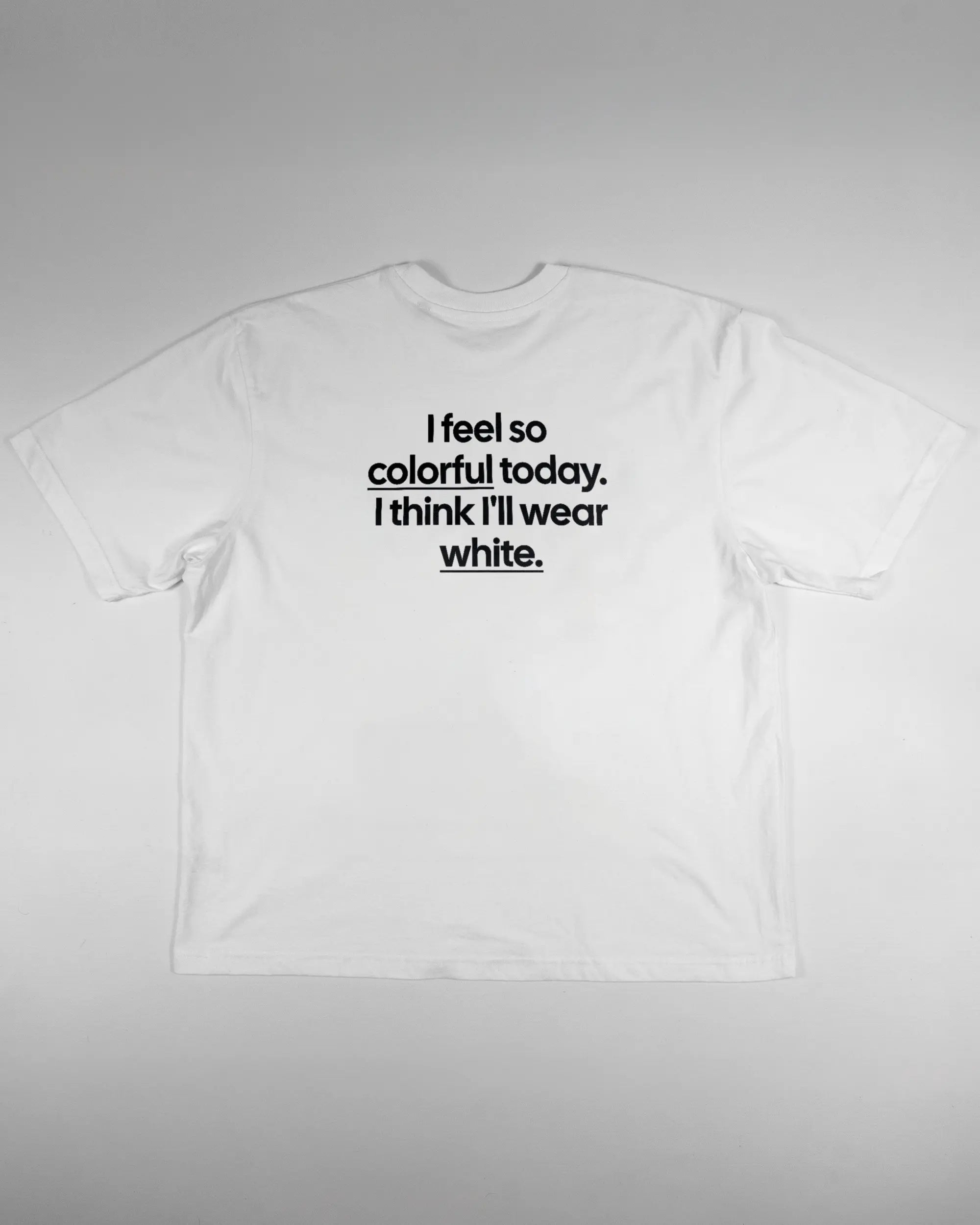 Rückseite des Basic Unisex T-Shirt Oversized von Maondo mit dem Design Colorful Day in der Farbe White und in der Größe L flach auf den Boden gelegt