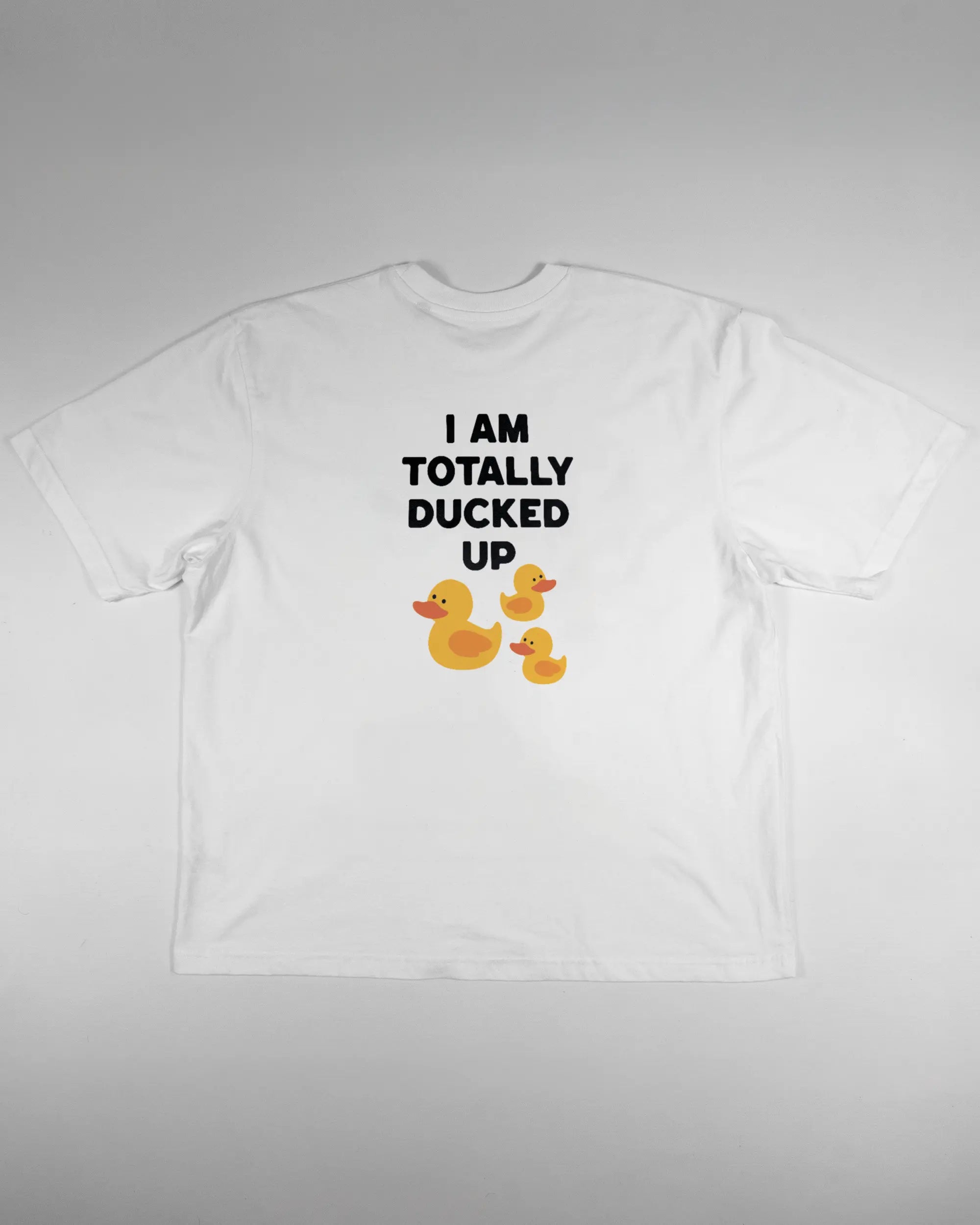 Rückseite des Basic Unisex T-Shirt Oversized von Maondo mit dem Design Ducked Up in der Farbe White und in der Größe L flach auf den Boden gelegt
