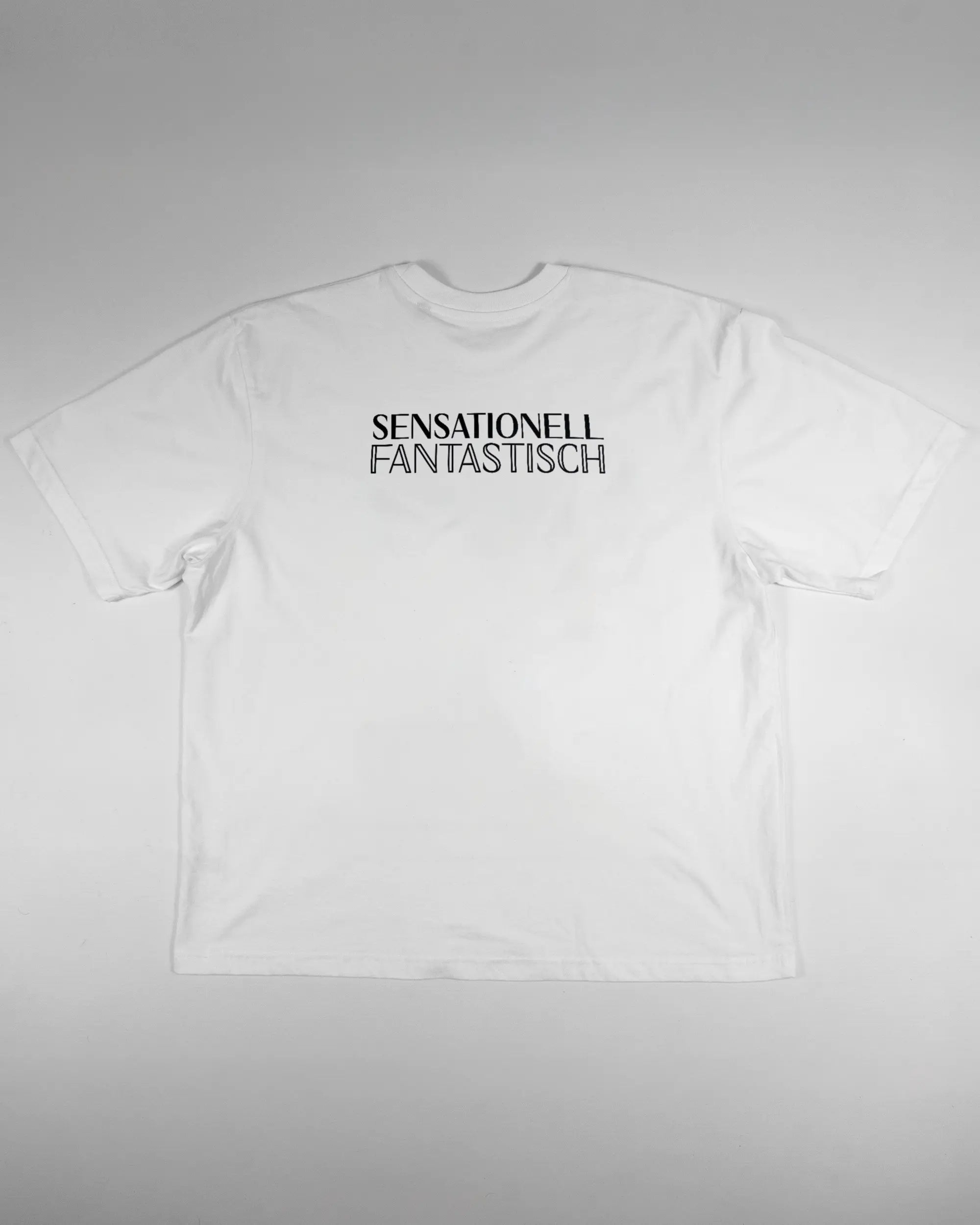 Rückseite des Basic Unisex T-Shirt Oversized von Maondo mit dem Design Sensationell in der Farbe White und in der Größe L flach auf den Boden gelegt