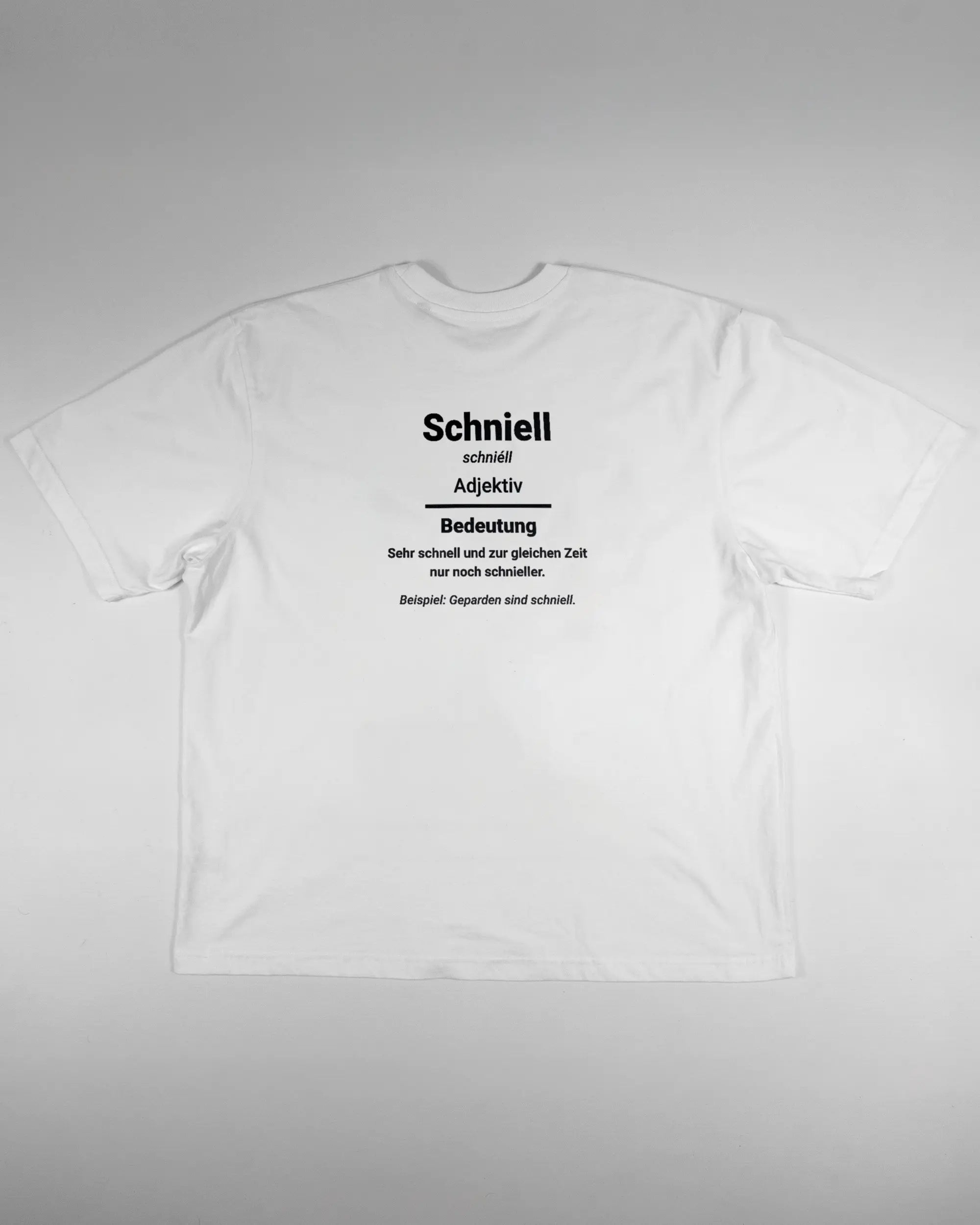 Rückseite des Basic Unisex T-Shirt Oversized von Maondo mit dem Design Schniell in der Farbe White und in der Größe L flach auf den Boden gelegt