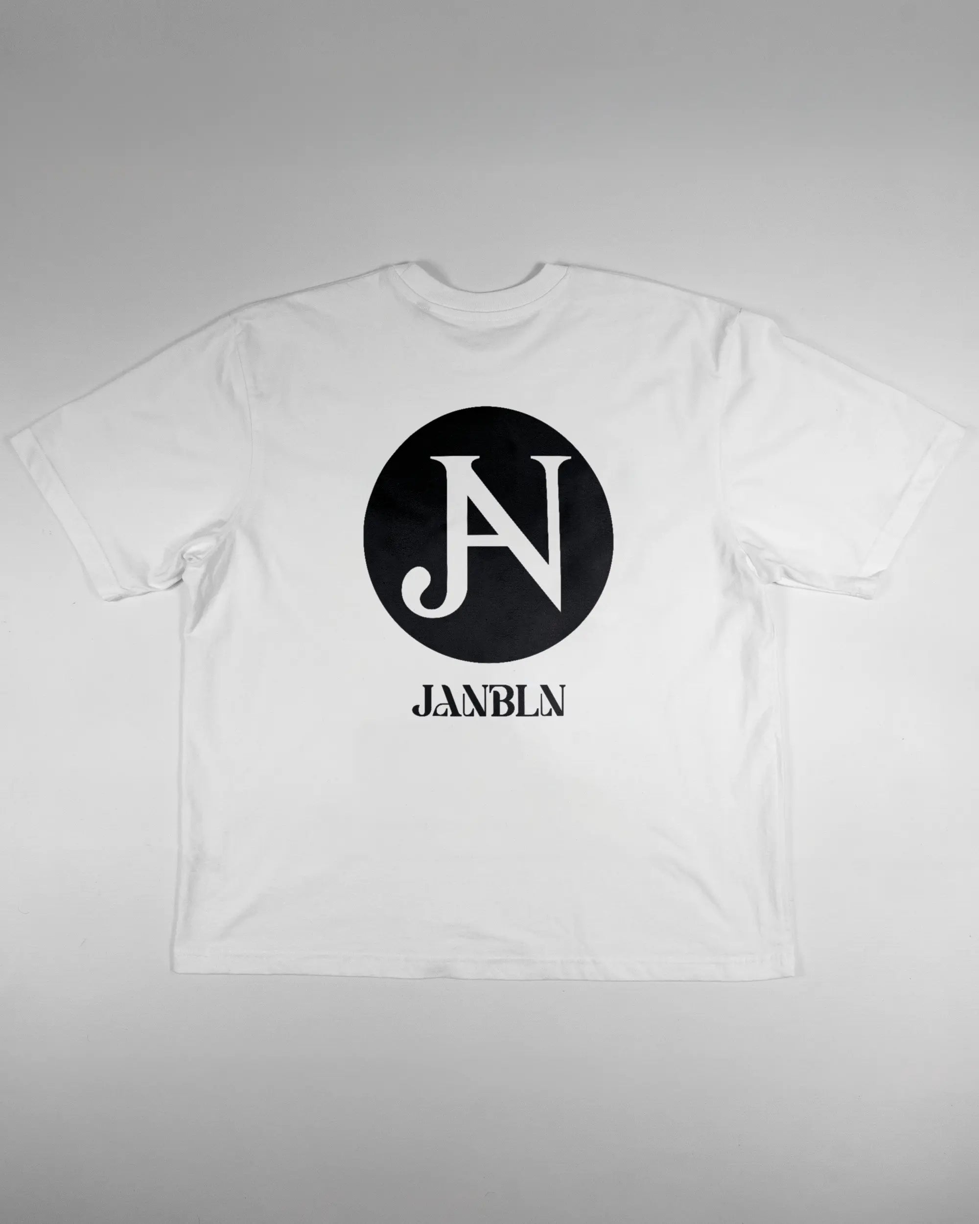 Rückseite des Basic Unisex T-Shirt Oversized von Maondo mit dem Design JB1 in der Farbe White und in der Größe L flach auf den Boden gelegt
