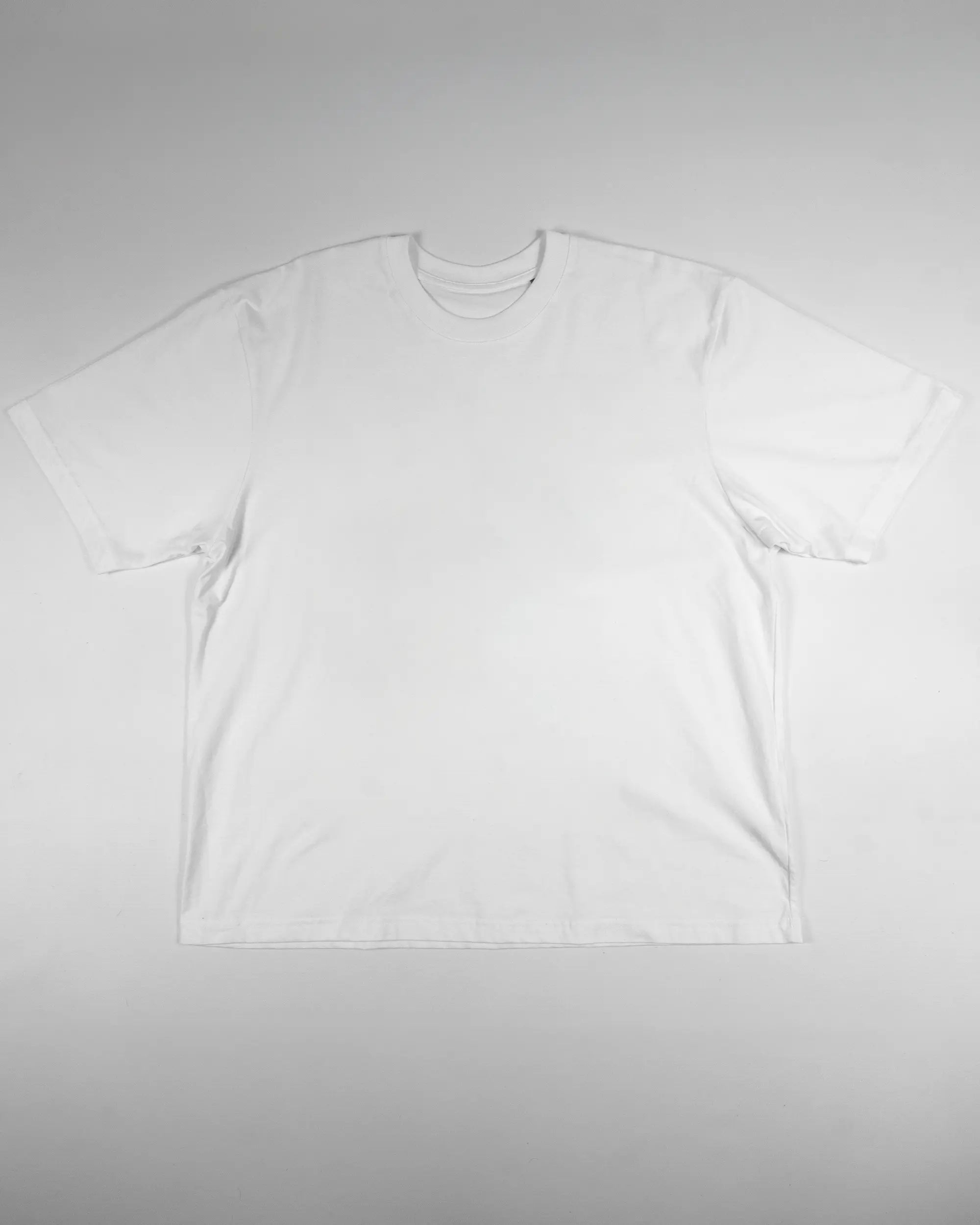 Vorderseite des Basic Unisex T-Shirt Oversized von Maondo ohne Motiv in der Farbe White und in der Größe L flach auf den Boden gelegt