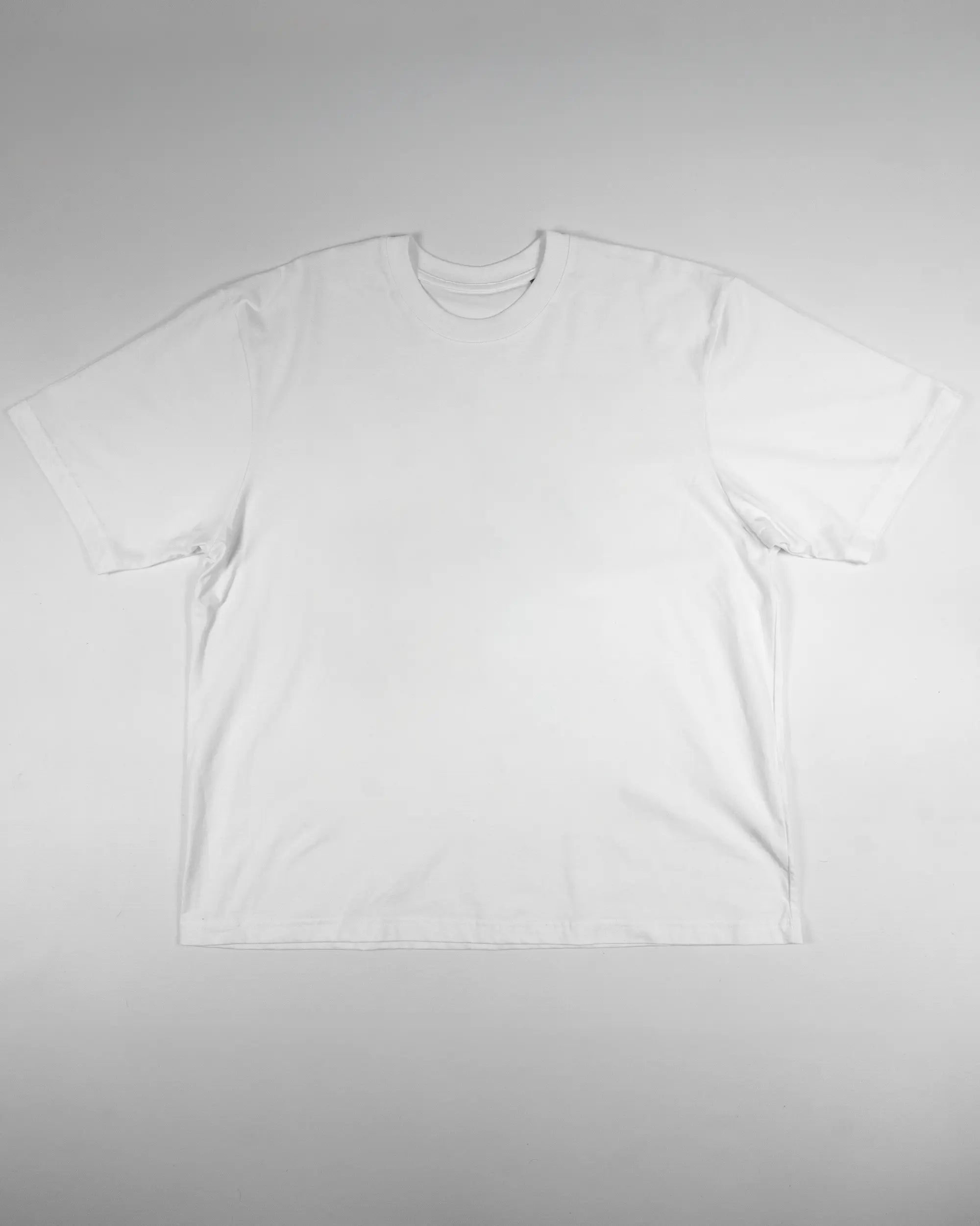 Vorderseite des Basic Unisex T-Shirt Oversized von Maondo ohne Motiv in der Farbe White und in der Größe L flach auf den Boden gelegt
