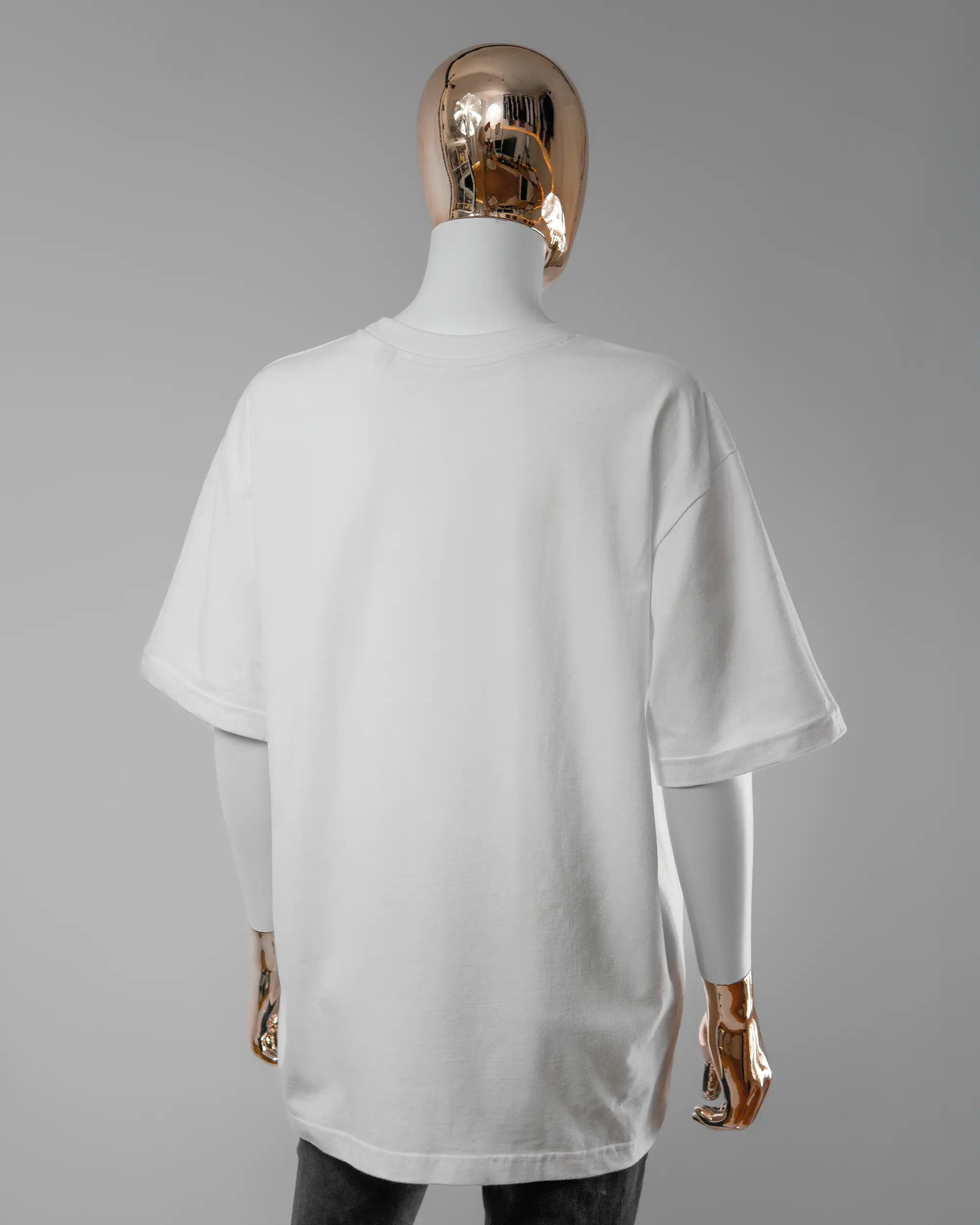 Rückseite des Basic Unisex T-Shirt Oversized von Maondo ohne Motiv in der Farbe White und in der Größe S getragen von einer femininen Puppe