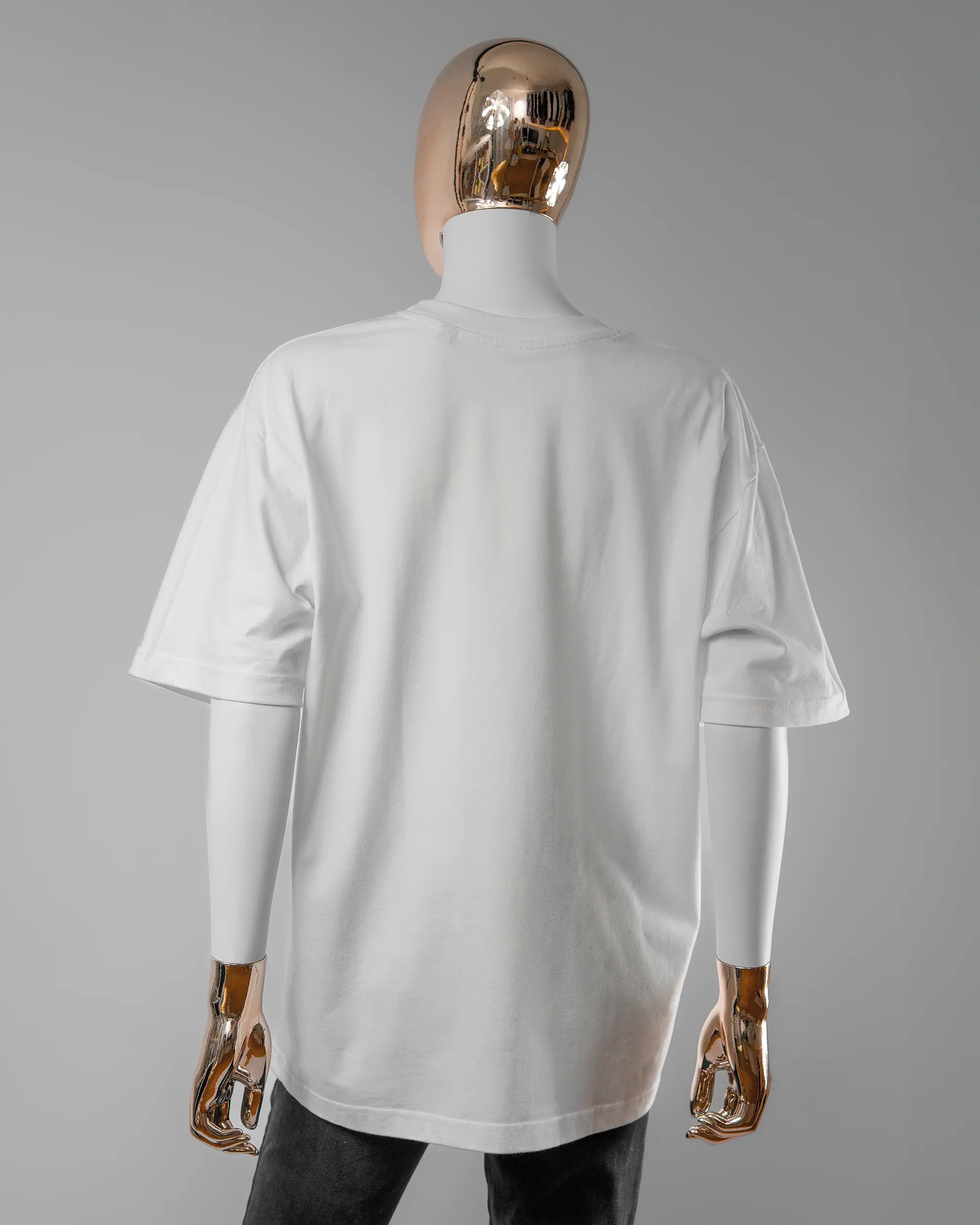 Rückseite des Basic Unisex T-Shirt Oversized von Maondo ohne Motiv in der Farbe White und in der Größe S getragen von einer femininen Puppe