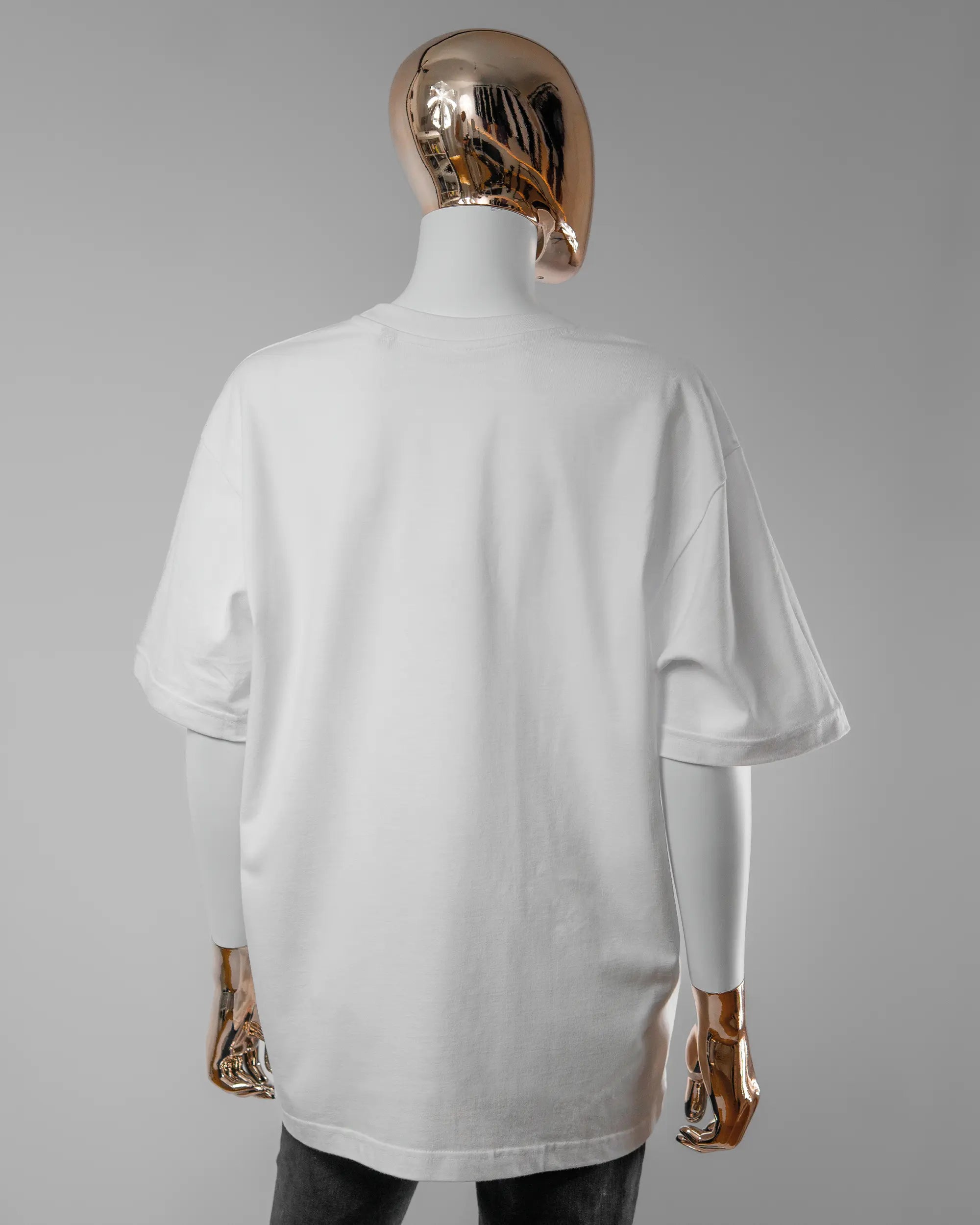 Rückseite des Basic Unisex T-Shirt Oversized von Maondo ohne Motiv in der Farbe White und in der Größe S getragen von einer femininen Puppe