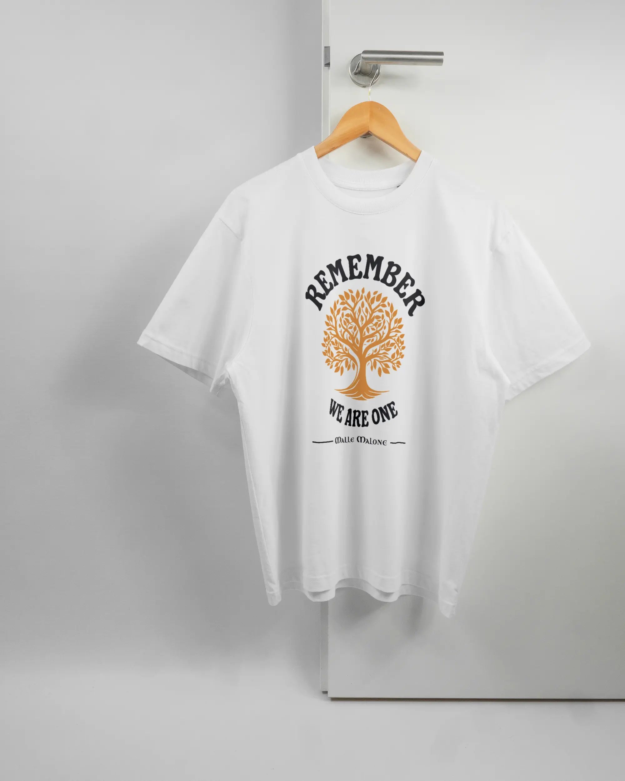 Vorderseite des Basic Unisex T-Shirt Oversized von Maondo mit dem Design We are one in der Farbe White und in der Größe S auf einem Bügel an der Türklinke aufgehängt