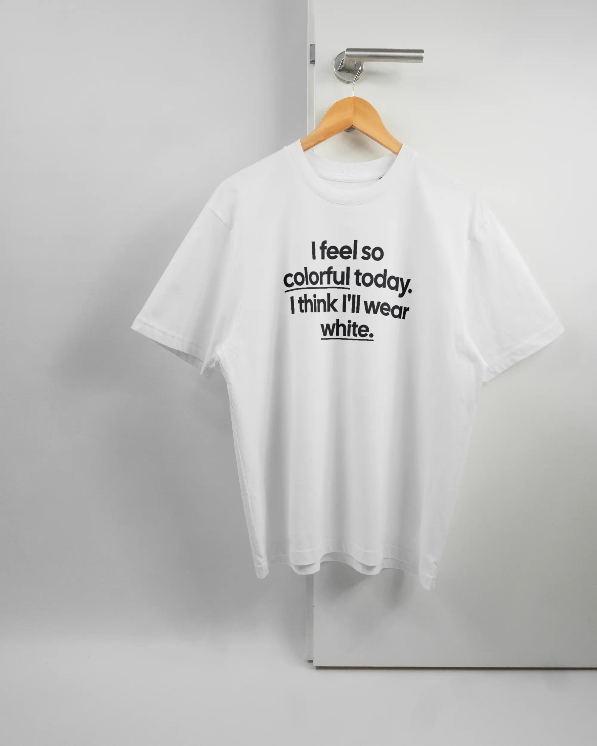 Vorderseite des Basic Unisex T-Shirt Oversized von Maondo mit dem Design Colorful Day in der Farbe White und in der Größe S auf einem Bügel an der Türklinke aufgehängt