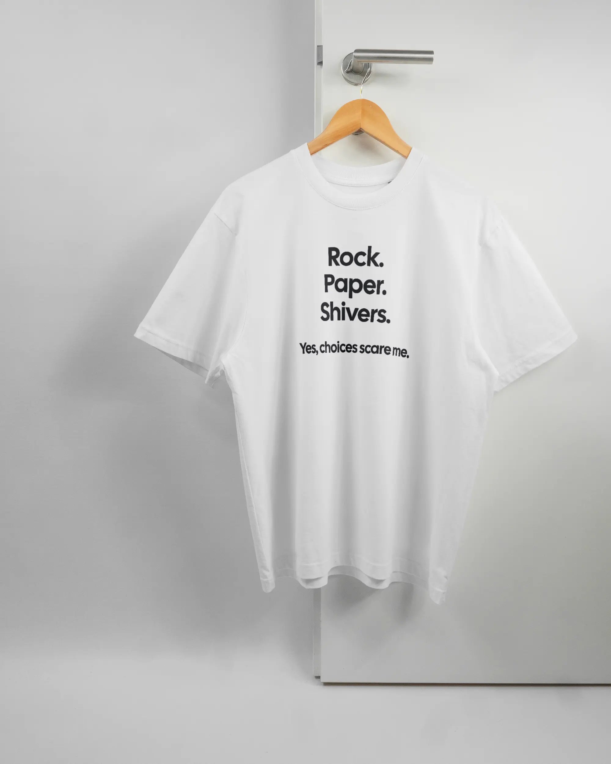 Vorderseite des Basic Unisex T-Shirt Oversized von Maondo mit dem Design Rock Paper Shivers in der Farbe White und in der Größe S auf einem Bügel an der Türklinke aufgehängt