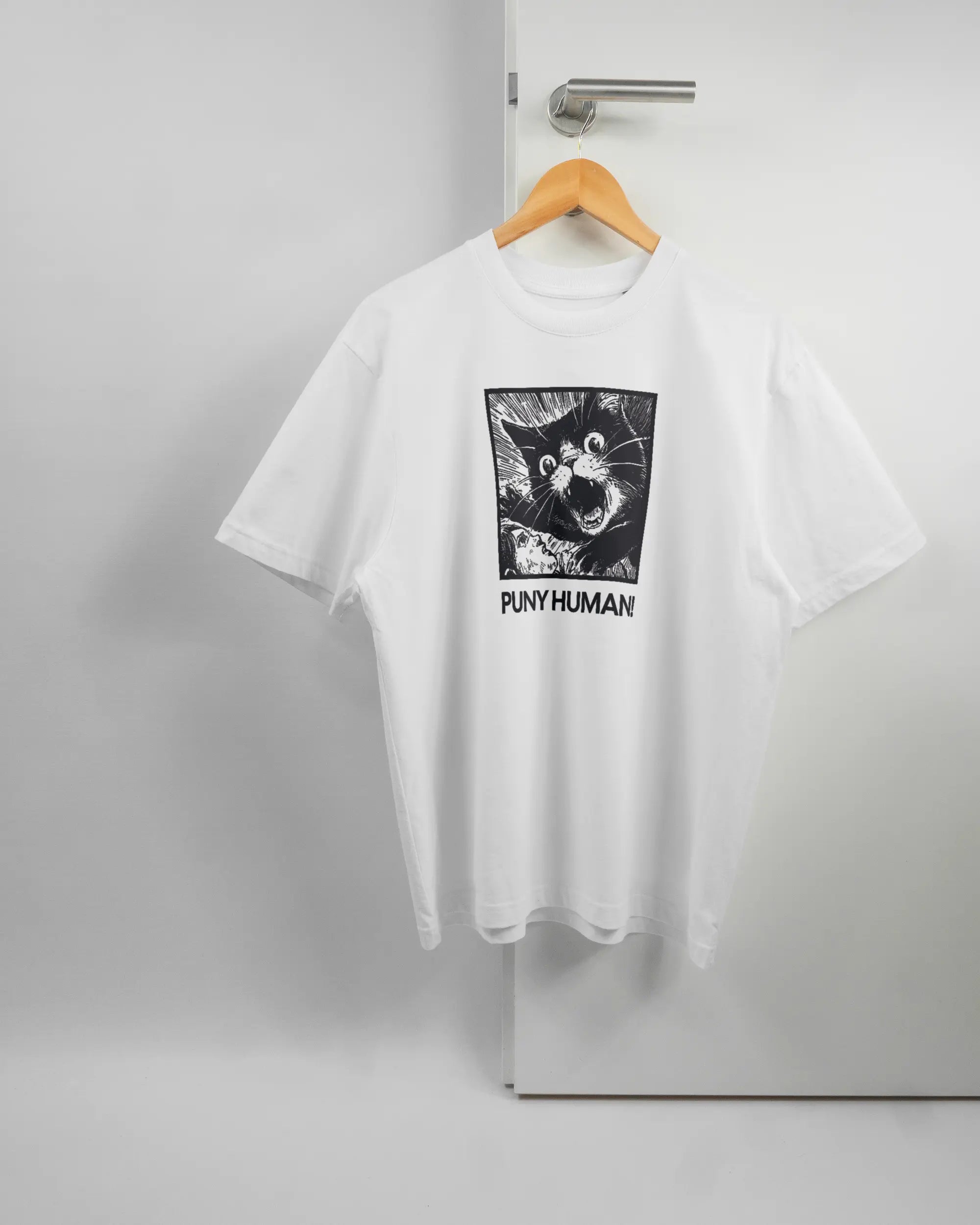 Vorderseite des Basic Unisex T-Shirt Oversized von Maondo mit dem Design Puny Human in der Farbe White und in der Größe S auf einem Bügel an der Türklinke aufgehängt