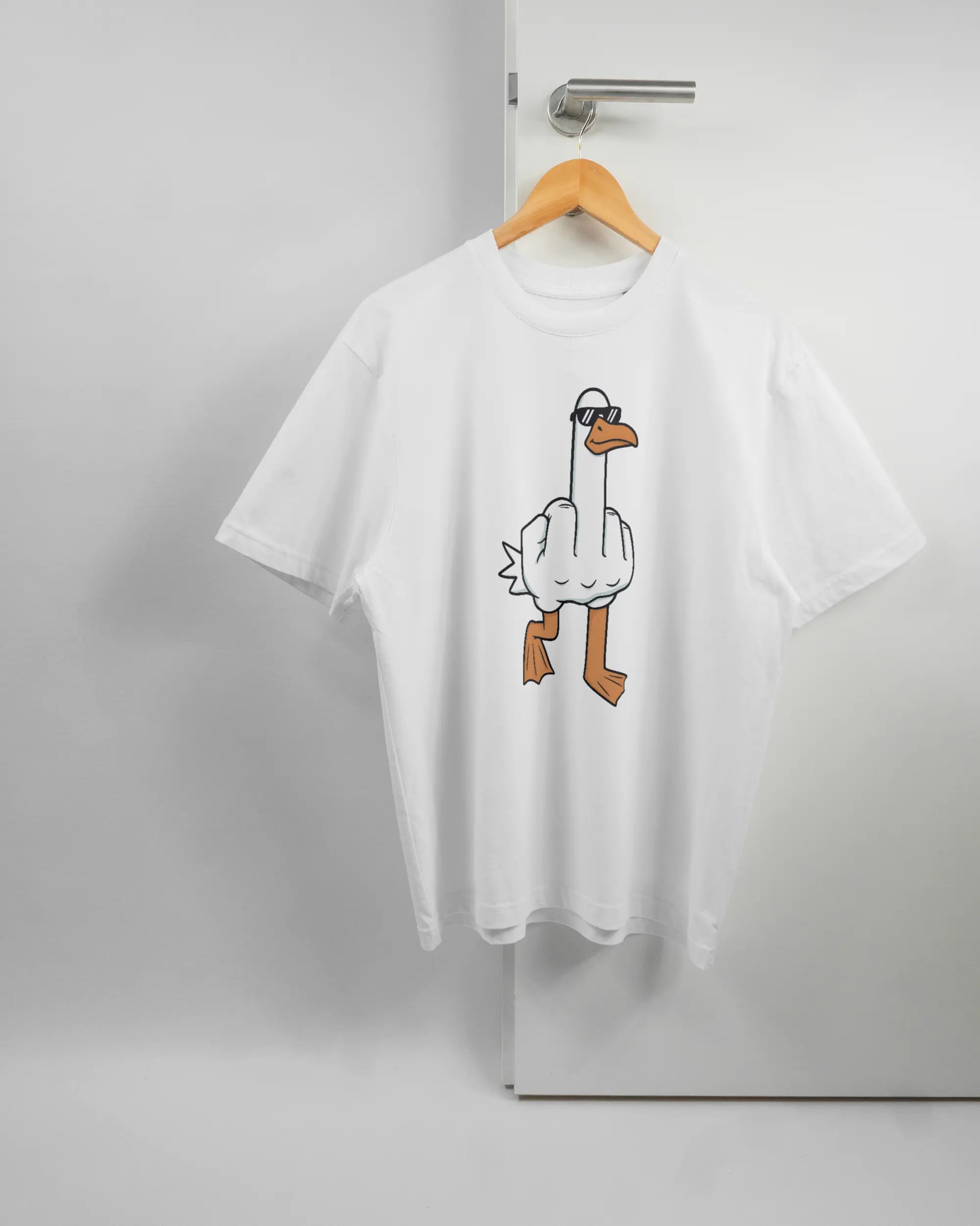 Vorderseite des Basic Unisex T-Shirt Oversized von Maondo mit dem Design I give a duck in der Farbe White und in der Größe S auf einem Bügel an der Türklinke aufgehängt