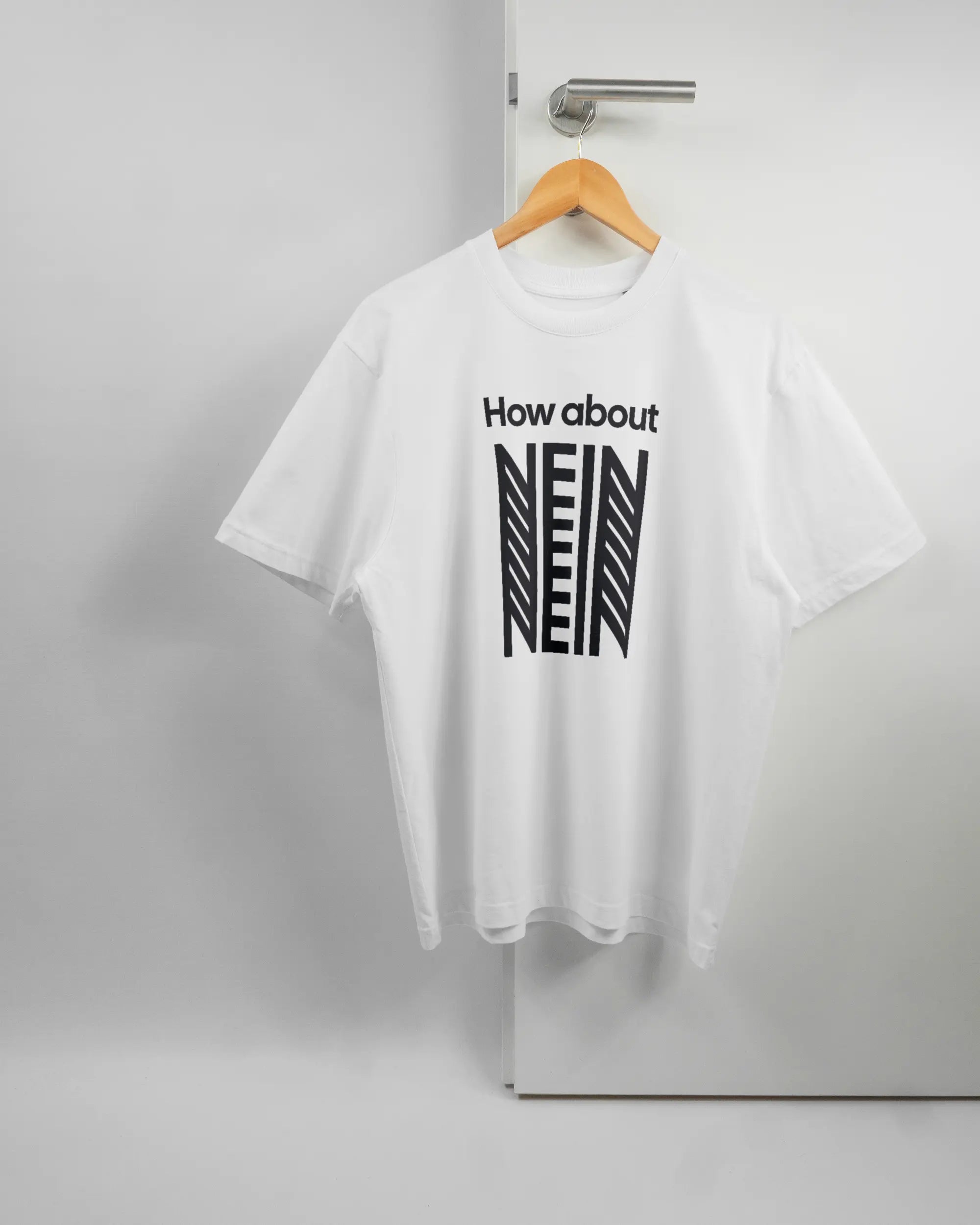 Vorderseite des Basic Unisex T-Shirt Oversized von Maondo mit dem Design How about nein in der Farbe White und in der Größe S auf einem Bügel an der Türklinke aufgehängt