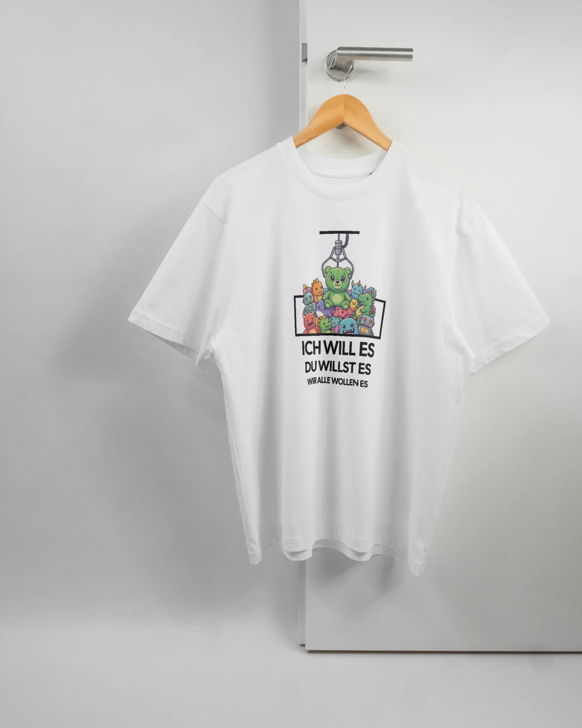 Vorderseite des Basic Unisex T-Shirt Oversized von Maondo mit dem Design Will Stofftier in der Farbe White und in der Größe S auf einem Bügel an der Türklinke aufgehängt