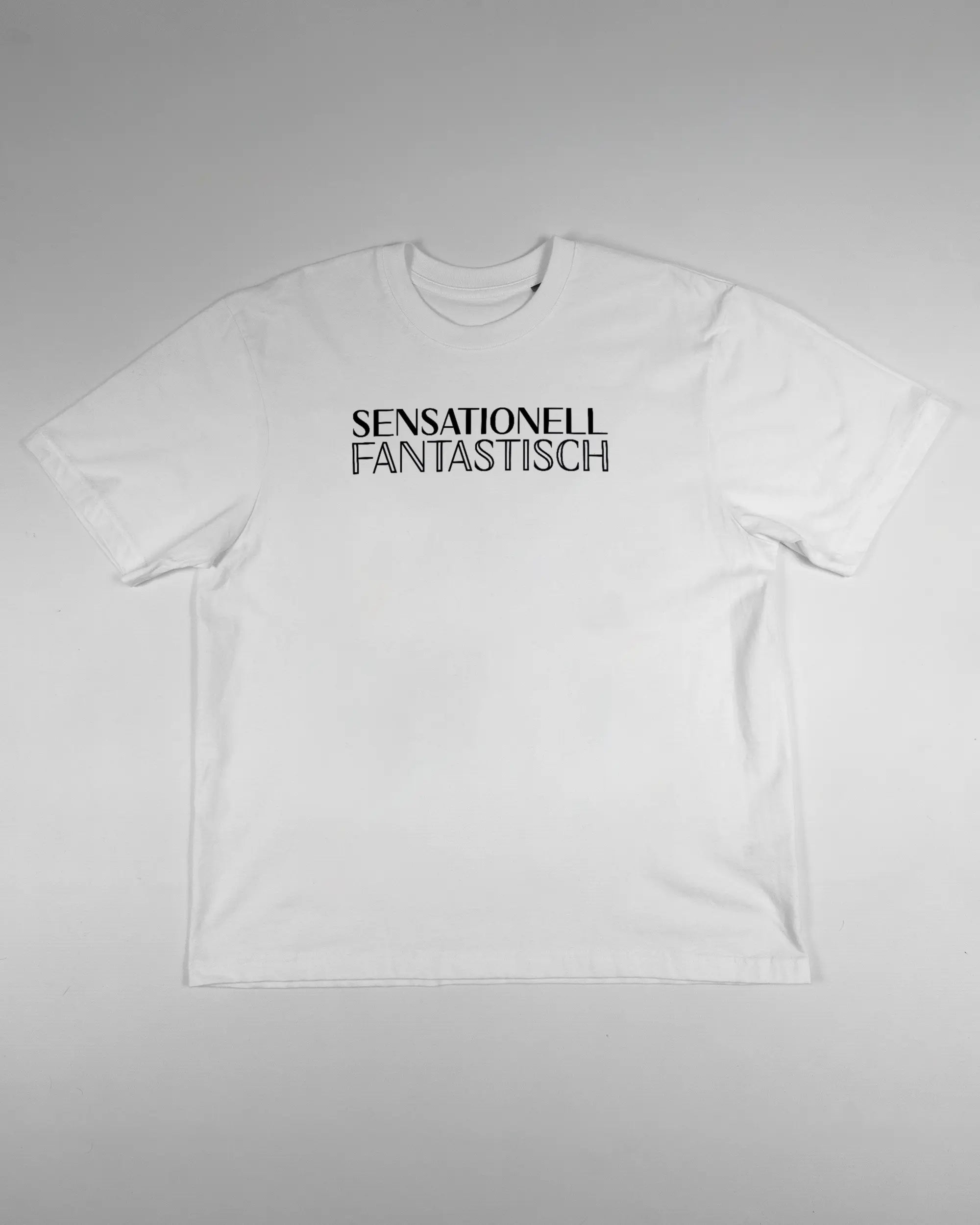 Vorderseite des Basic Unisex T-Shirt Oversized von Maondo mit dem Design Sensationell in der Farbe White und in der Größe S flach auf den Boden gelegt