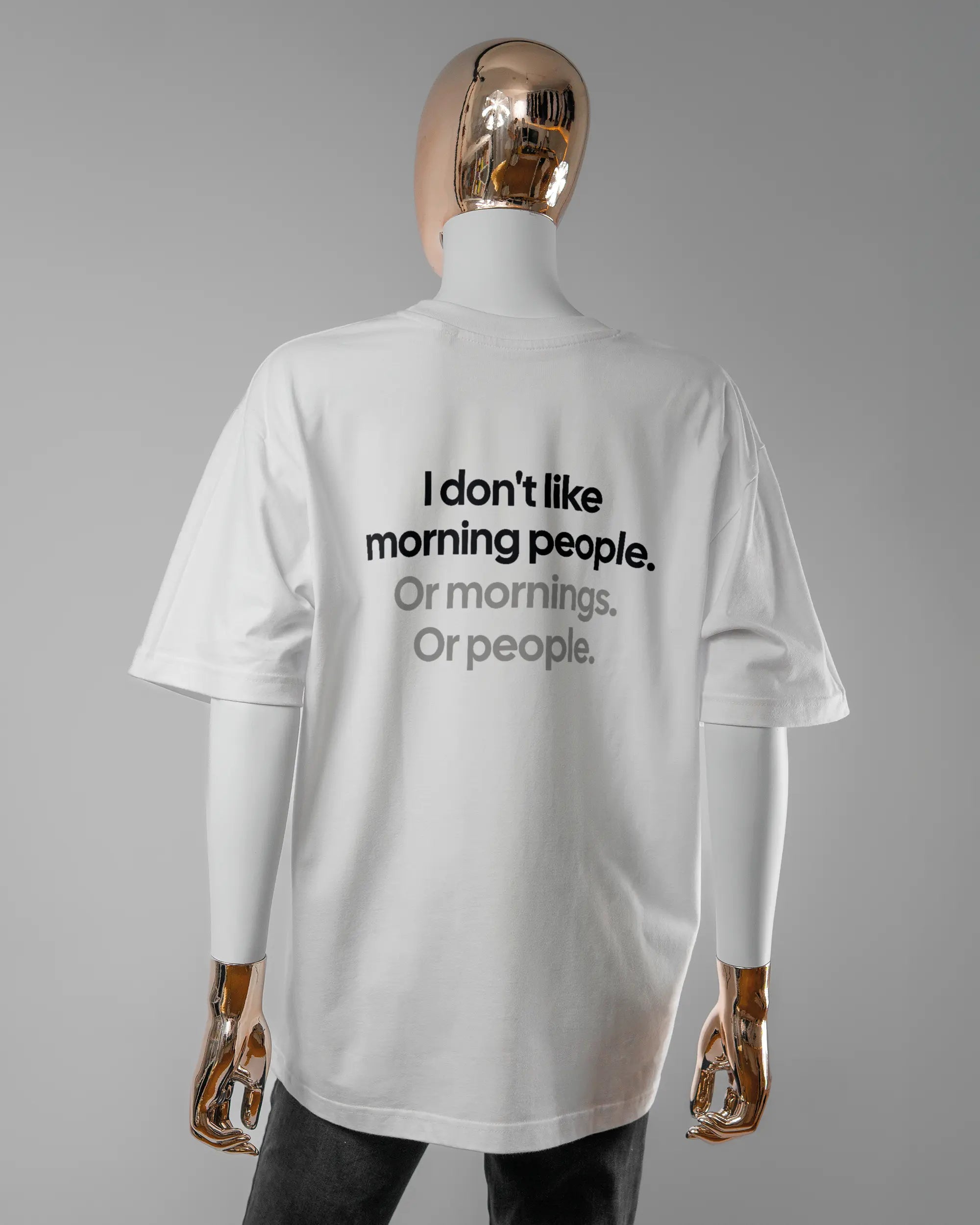 Rückseite des Basic Unisex T-Shirt Oversized von Maondo mit dem Design Morning Person in der Farbe White und in der Größe S getragen von einer femininen Puppe