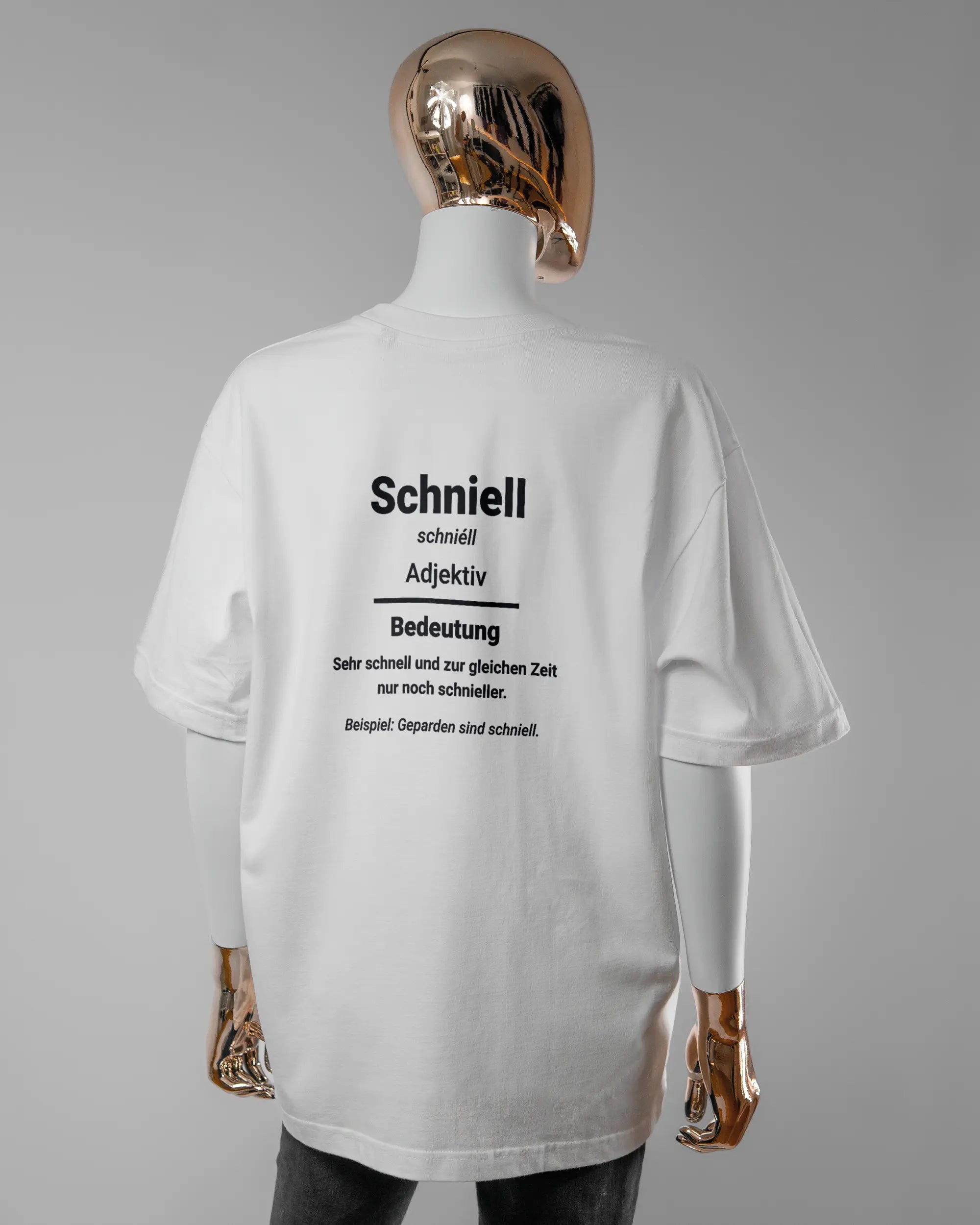 Rückseite des Basic Unisex T-Shirt Oversized von Maondo mit dem Design Schniell in der Farbe White und in der Größe S getragen von einer femininen Puppe