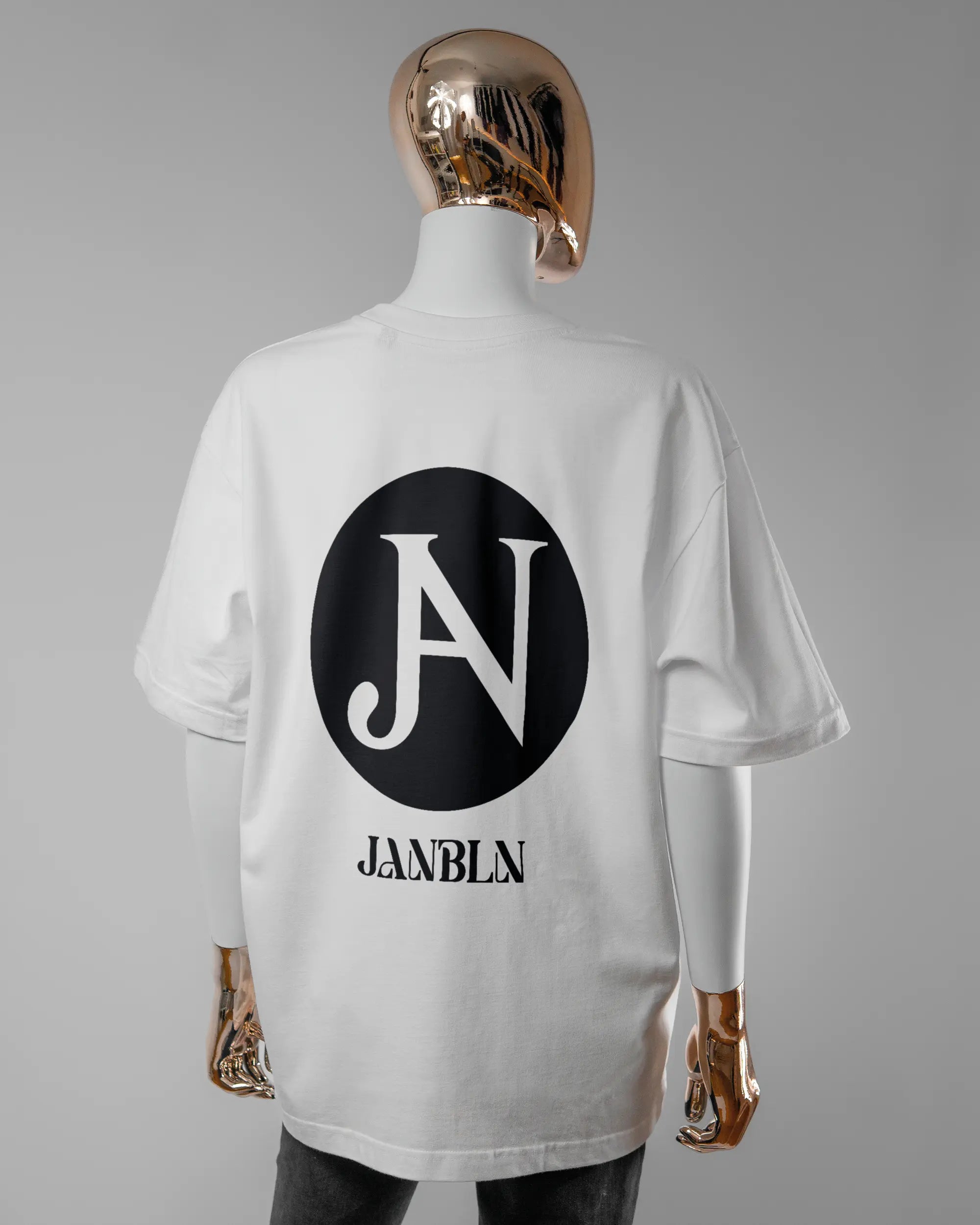 Rückseite des Basic Unisex T-Shirt Oversized von Maondo mit dem Design JB1 in der Farbe White und in der Größe S getragen von einer femininen Puppe